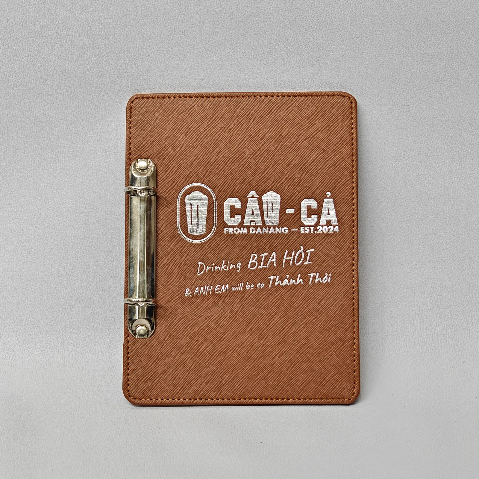 Charcoal gray leather A5 menu cover with embossed hotel branding
