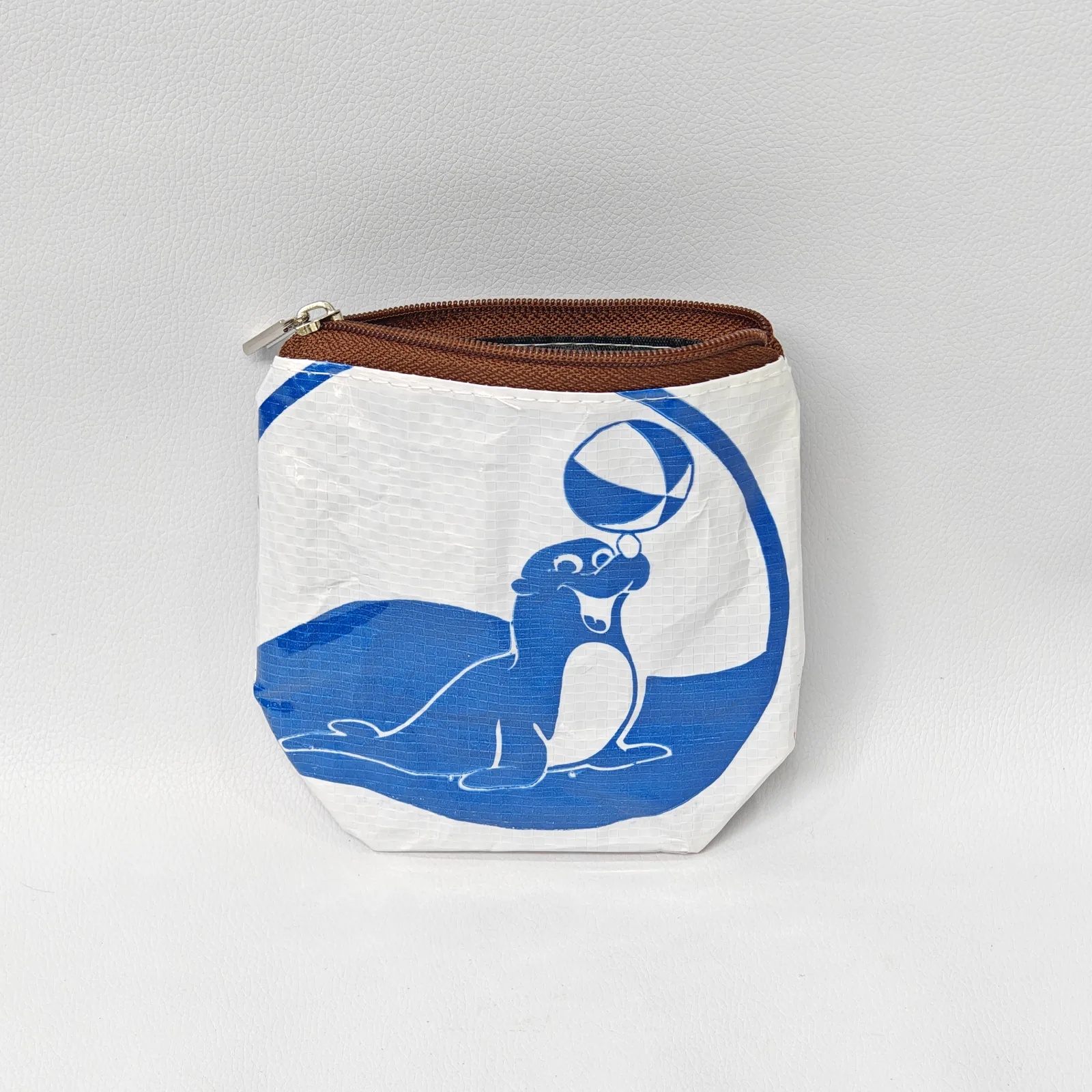 Blue seal-print canvas pouch with brown zipper and cream fabric edge binding