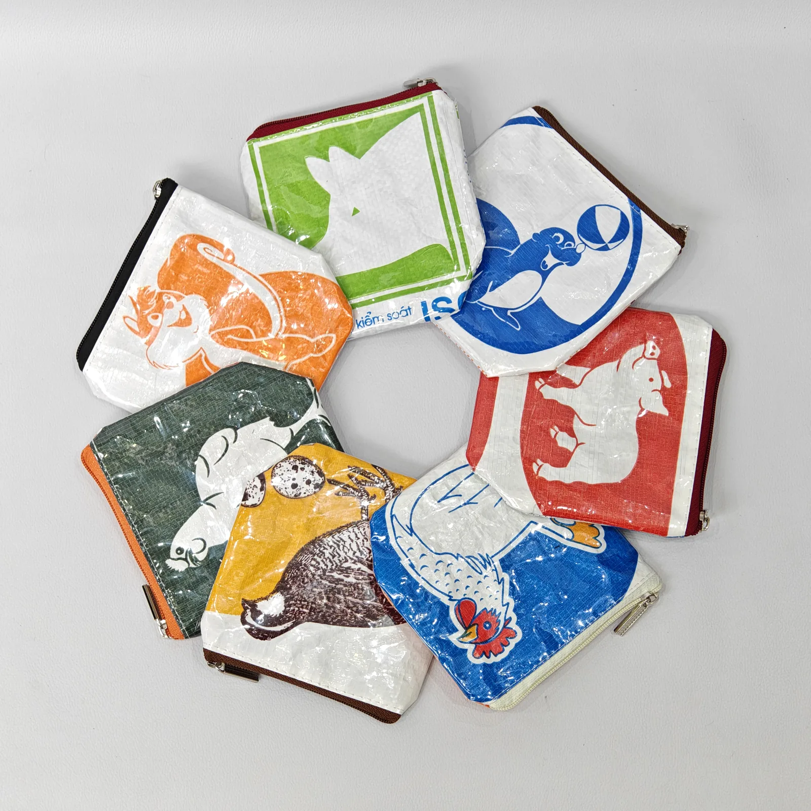 Complete collection display of 20+ animal-print canvas pouches showing all designs and color options