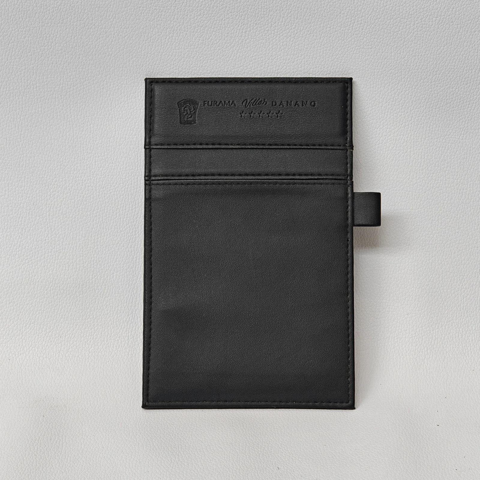 Black leather bill presenter with elastic band closure and embossed logo