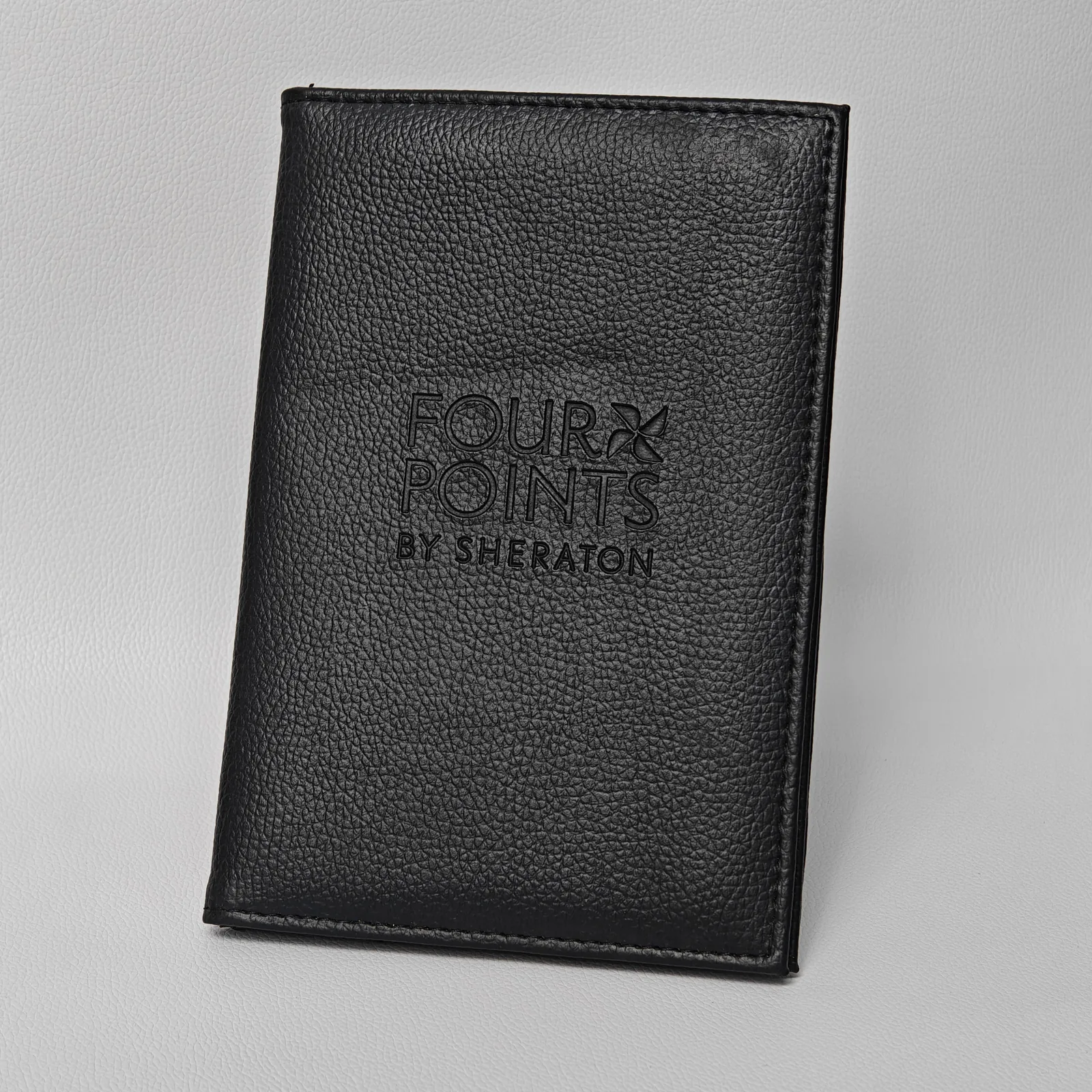 Angled view of black leather folder showing fold construction