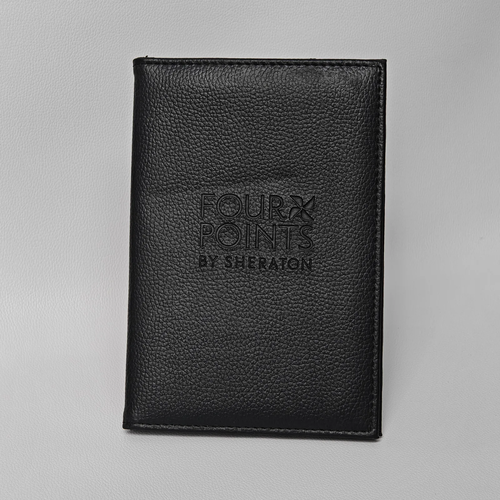 Black pebbled leather folder with embossed hotel branding