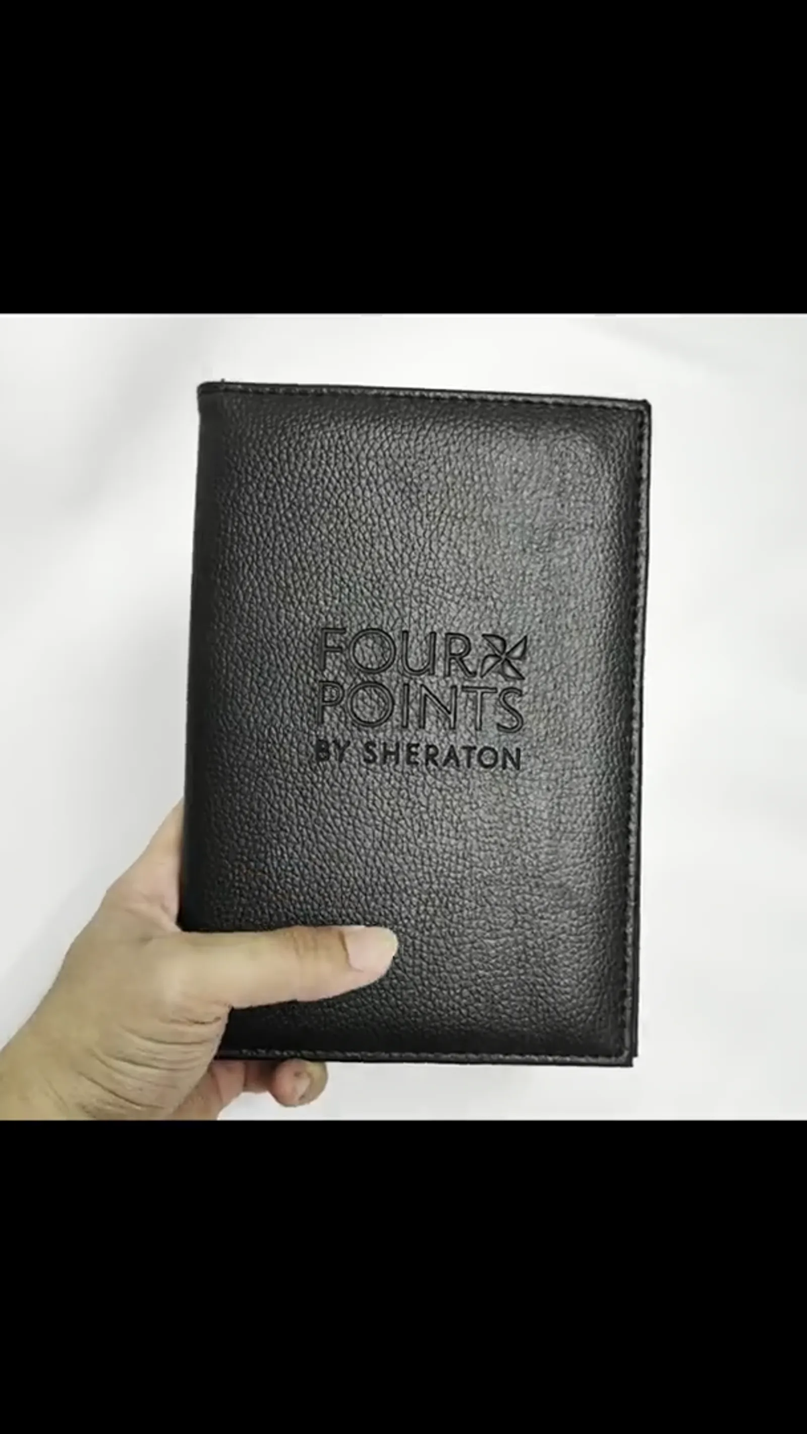Hands holding black leather folder demonstrating professional appearance