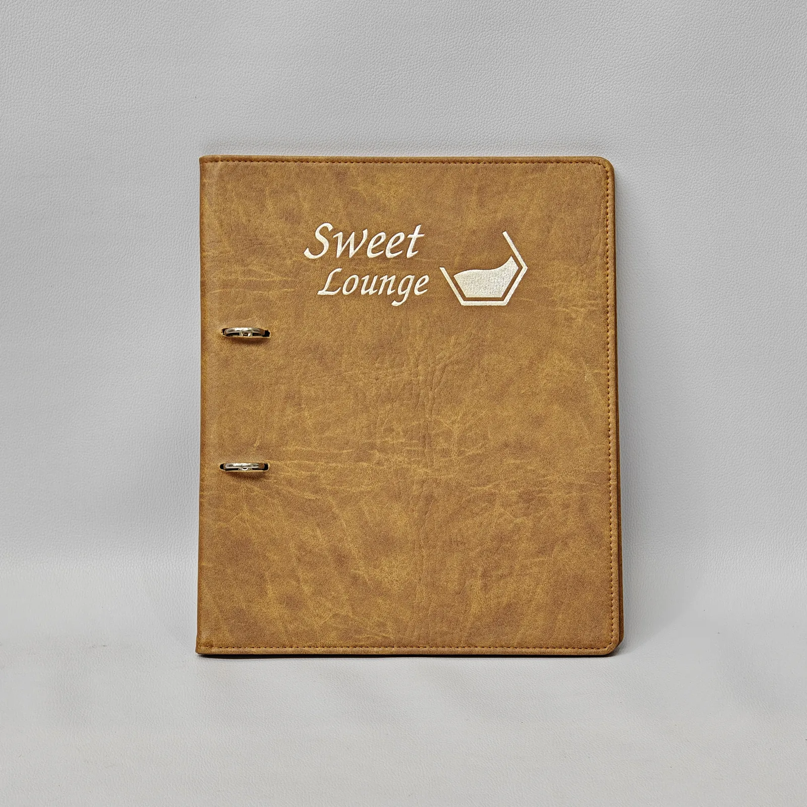 Front view of a brown textured ring binder with a white logo and visible metal rings.