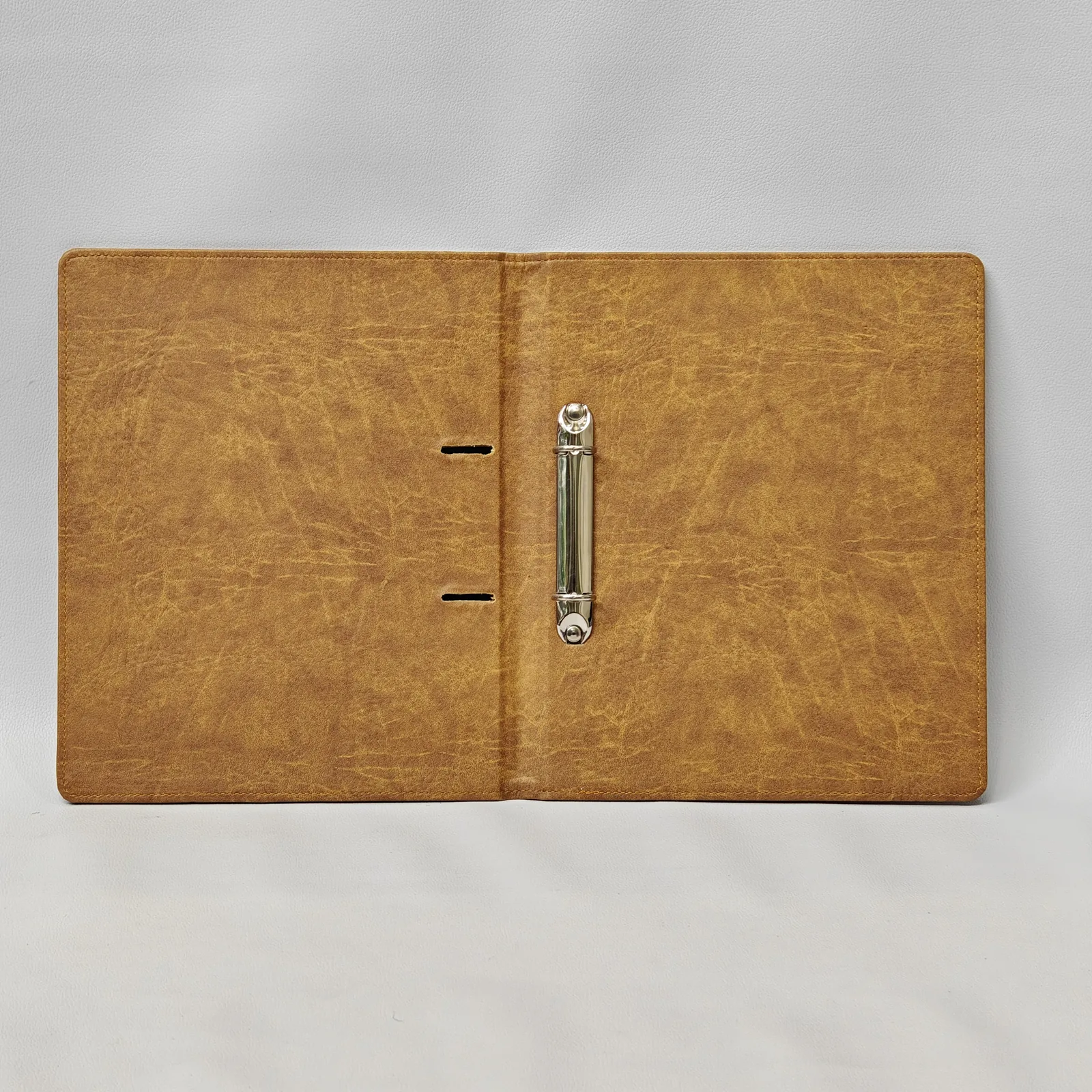 Open interior view of a brown textured binder showing a silver two-ring mechanism.
