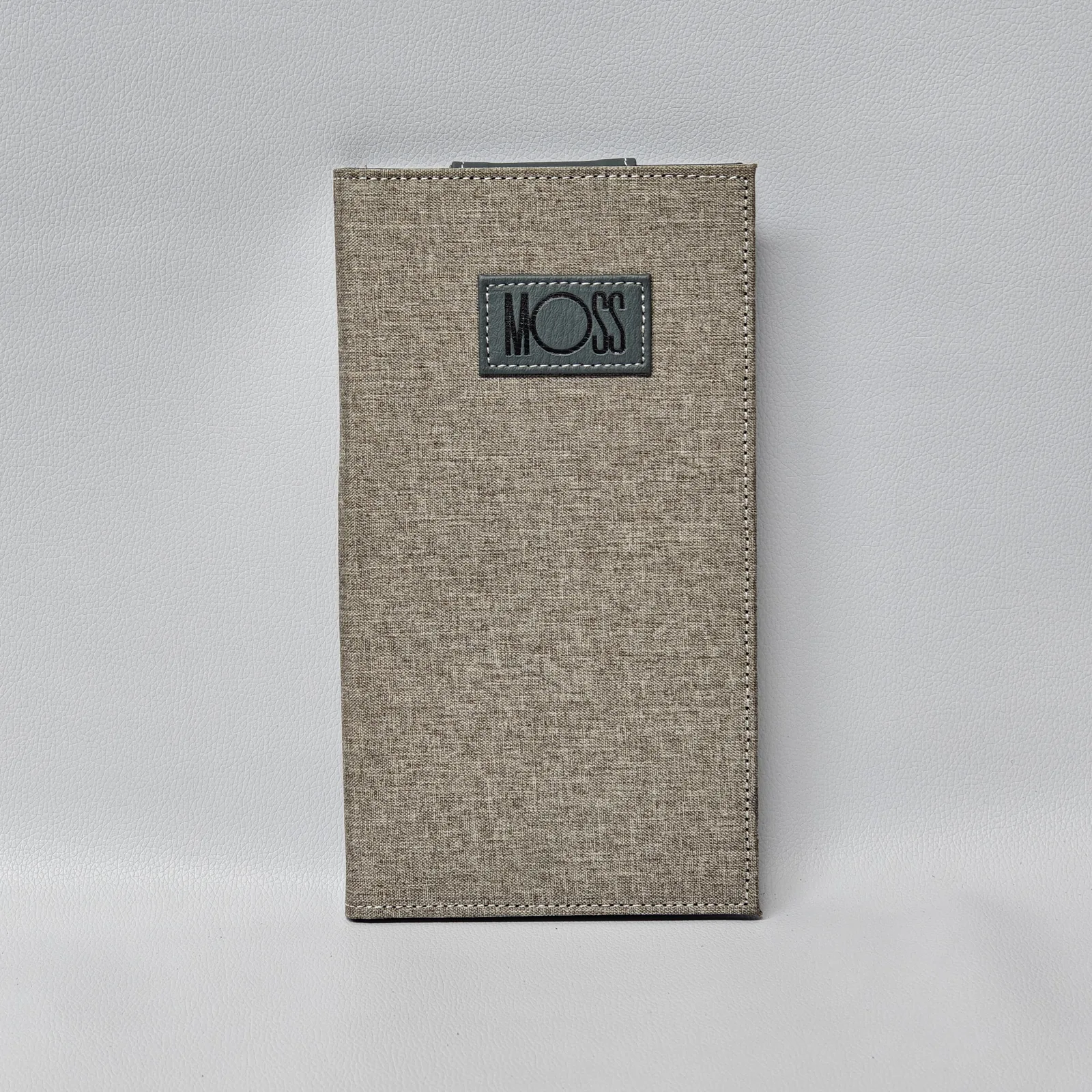 Canvas bill folder front showing tan exterior and gray leather logo patch