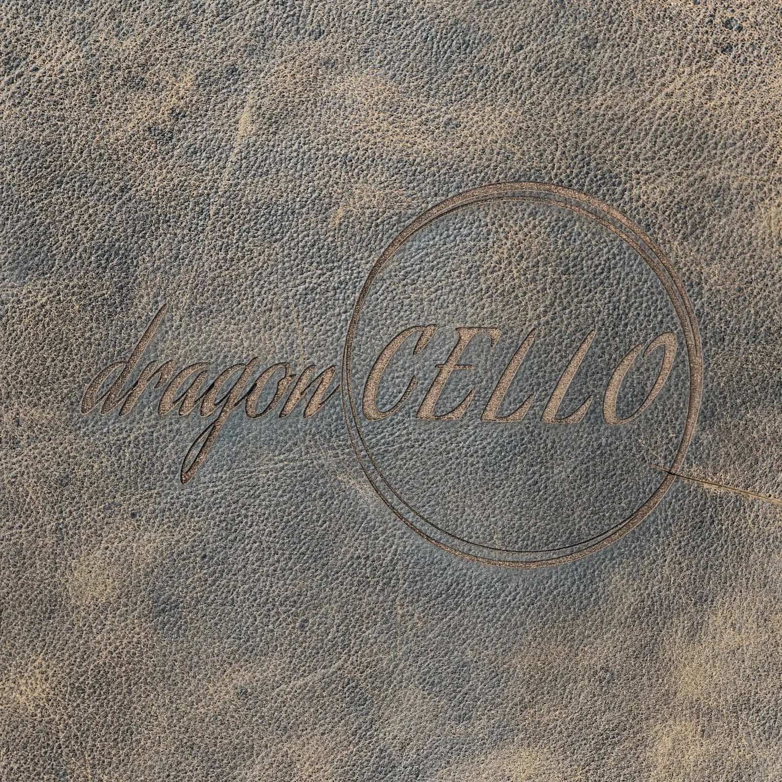 Detailed view of the pebbled texture of the brown leather and an embossed logo.