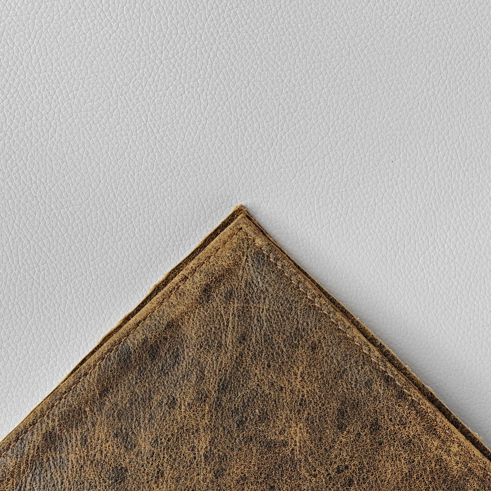 Close-up of the corner of the leather cover showing the neat perimeter stitching.