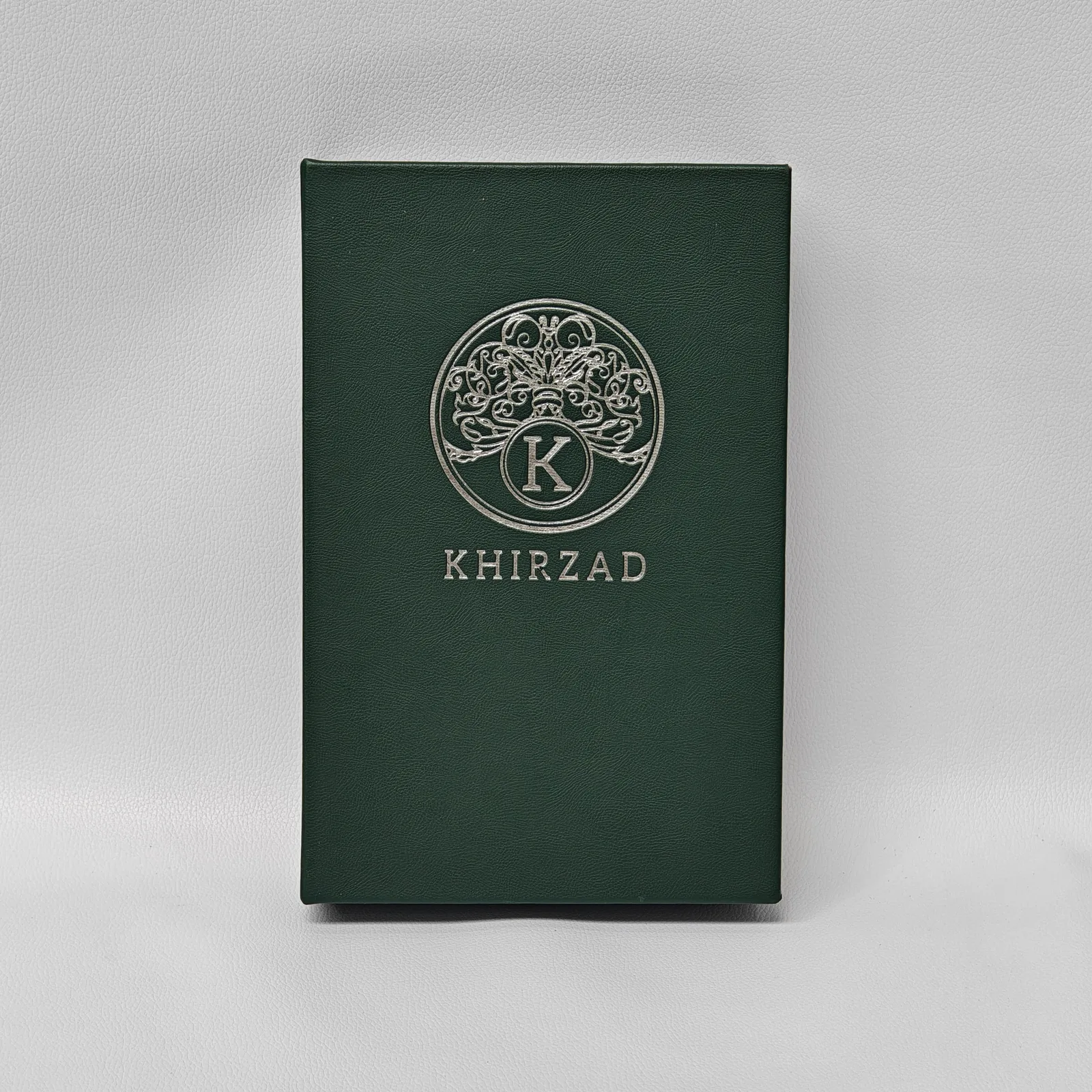 Emerald leather cover detail showing pebbled texture and embossed branding
