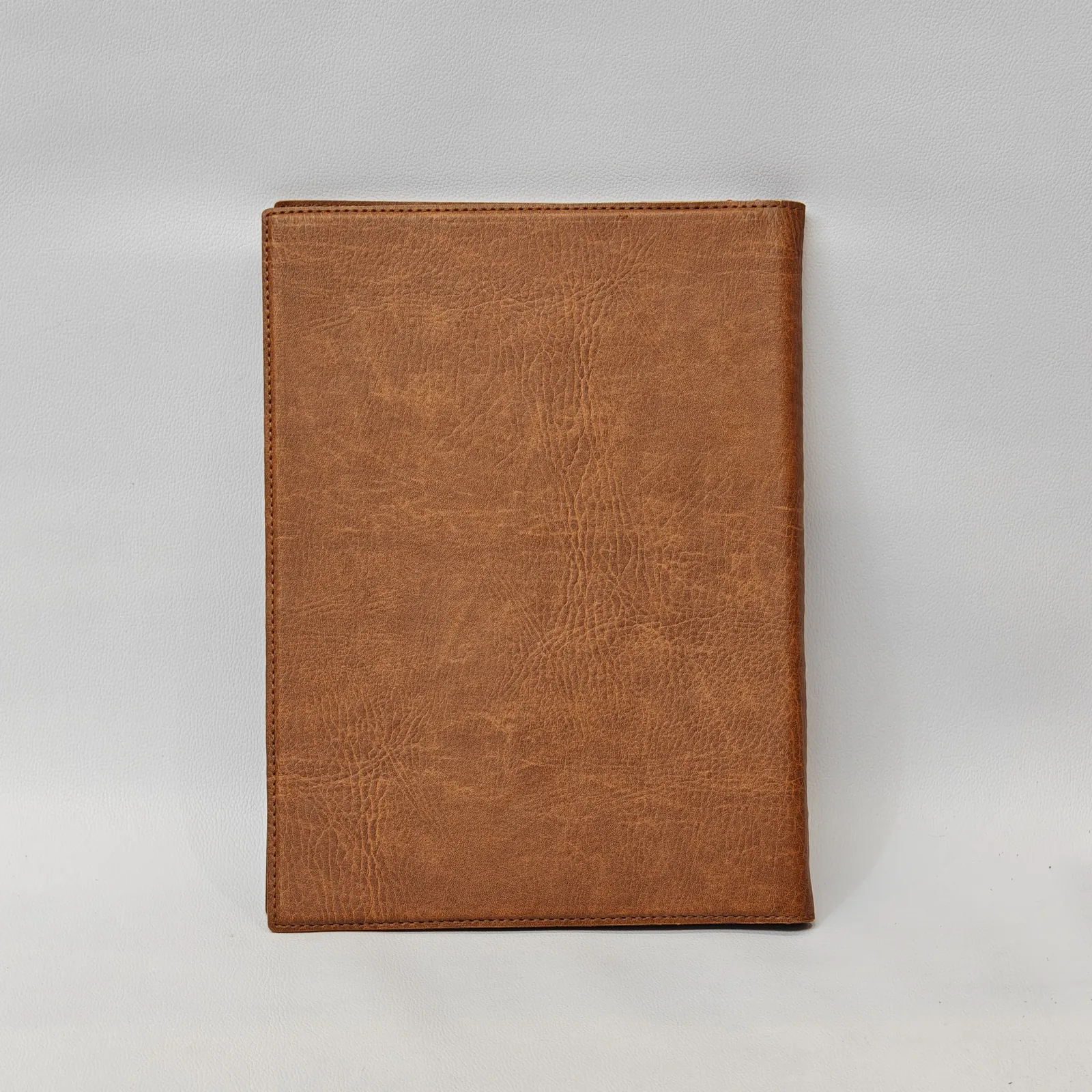 Back view of a brown textured menu cover with perimeter stitching.