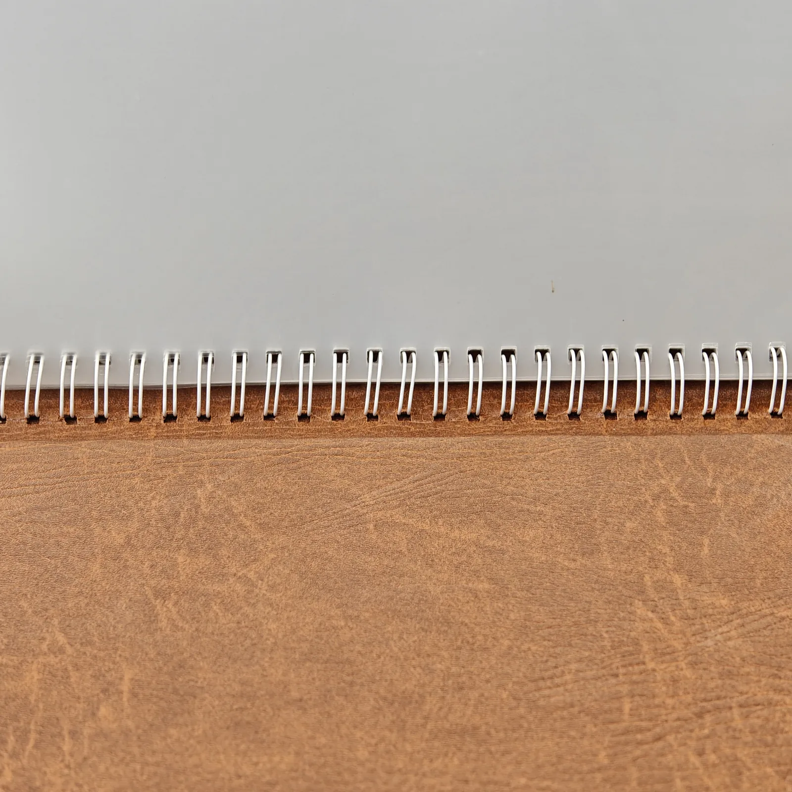 Detail of the white spiral binding and clear plastic insert inside a menu cover.