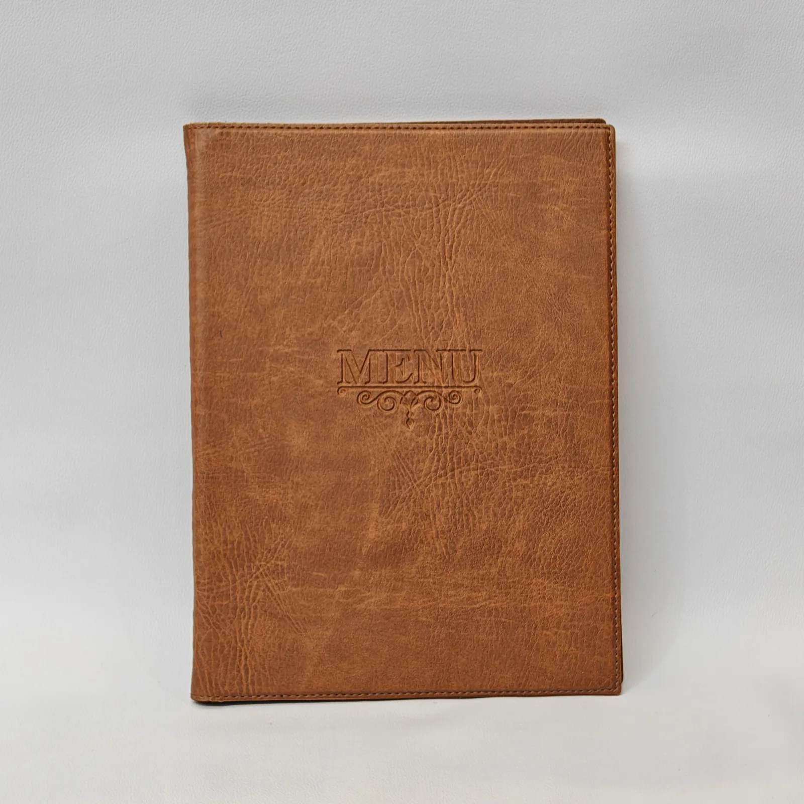 Front view of a brown textured menu cover with debossed text and perimeter stitching.