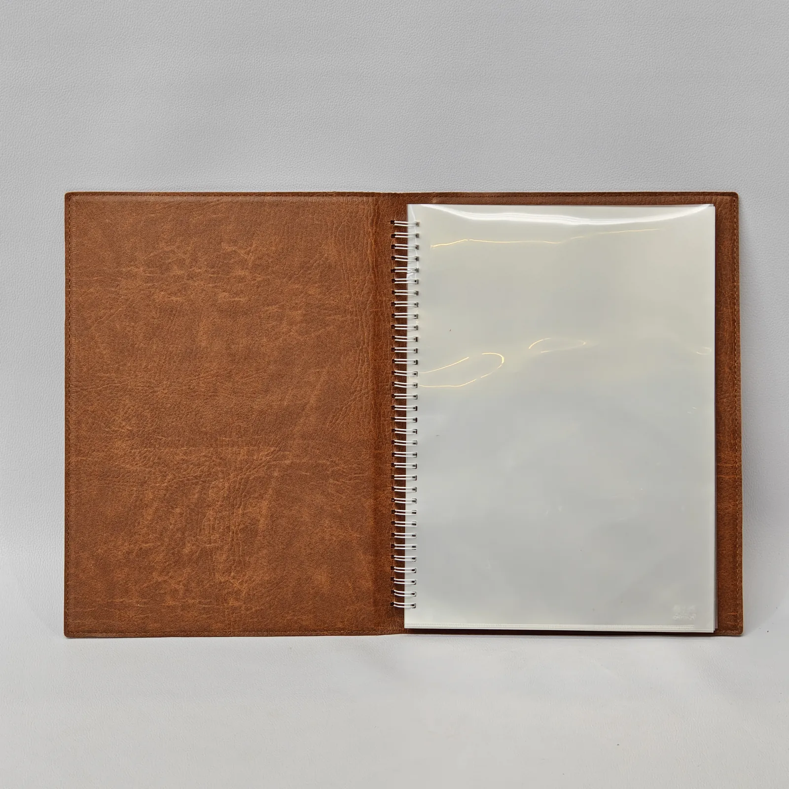Open menu cover showing a brown textured interior and a clear plastic sleeve.
