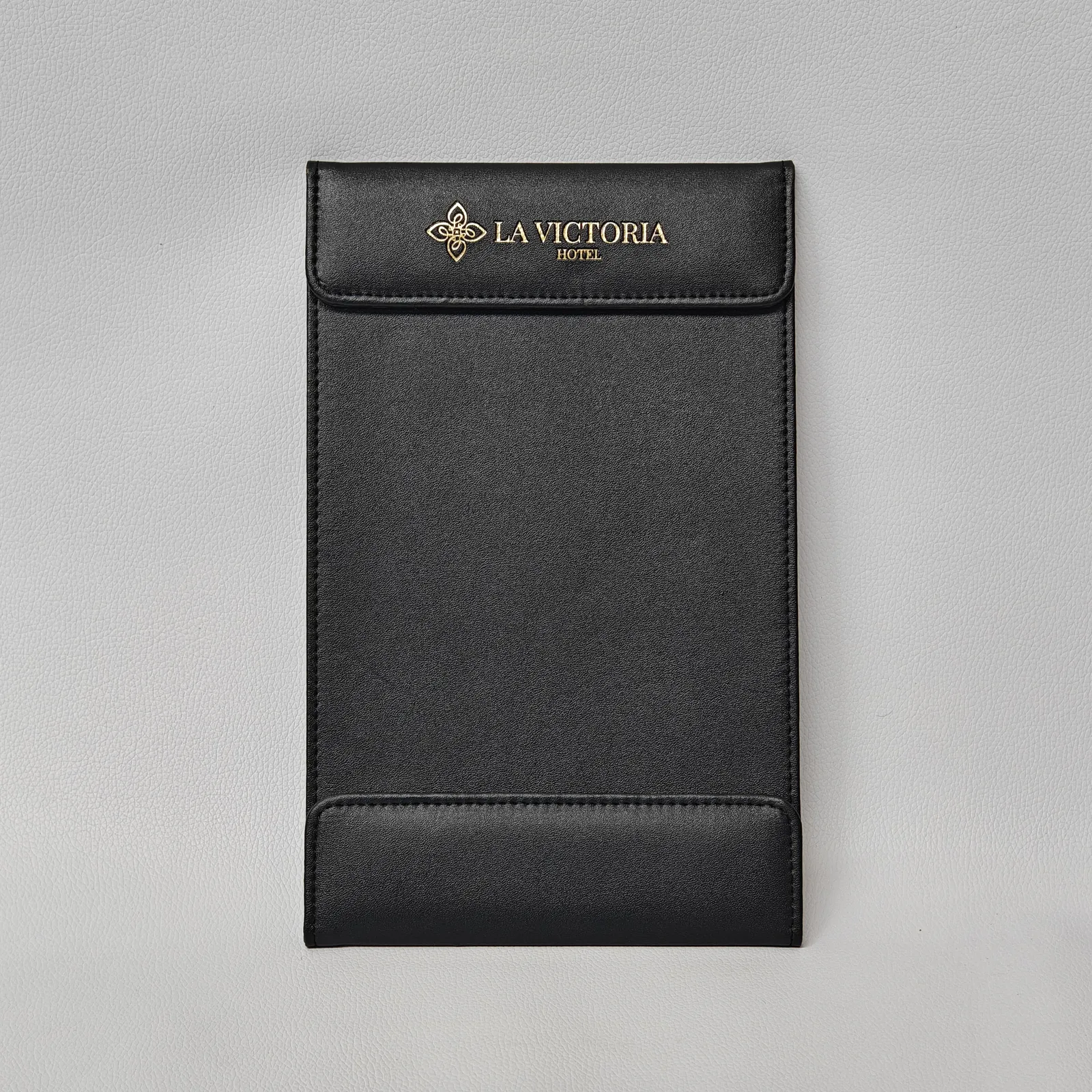 Black leather check presenter with gold foil logo and stitched top and bottom panels.