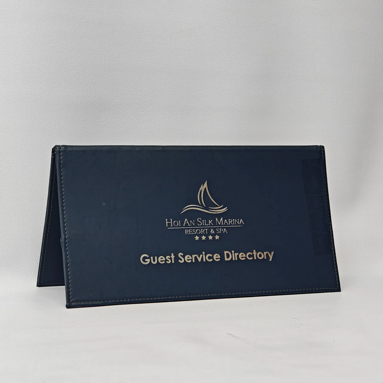 Navy leather guest service directory cover, landscape format with embossed logo