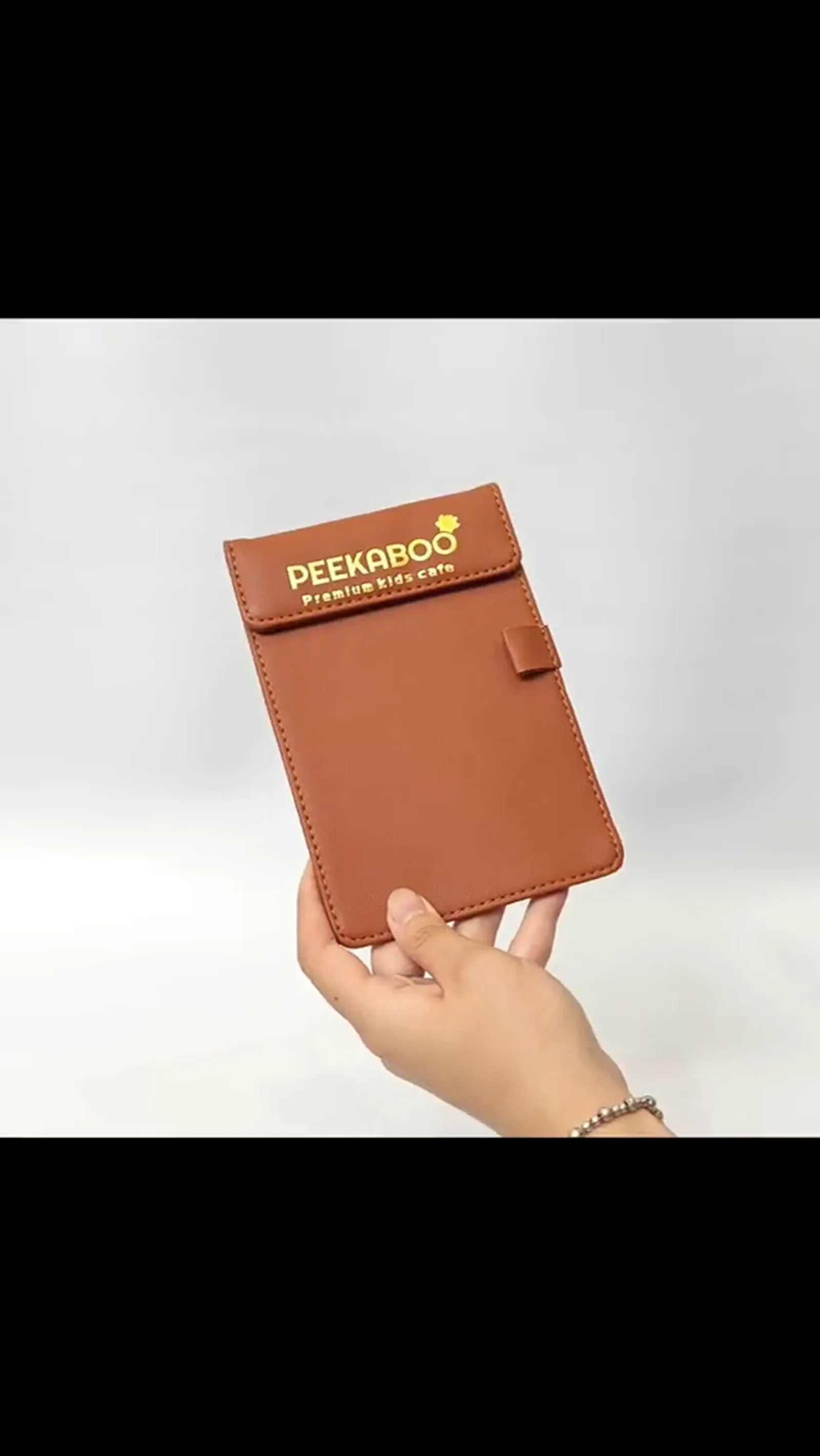 Leather pouch held in hand showing slim profile and portable size for restaurant use