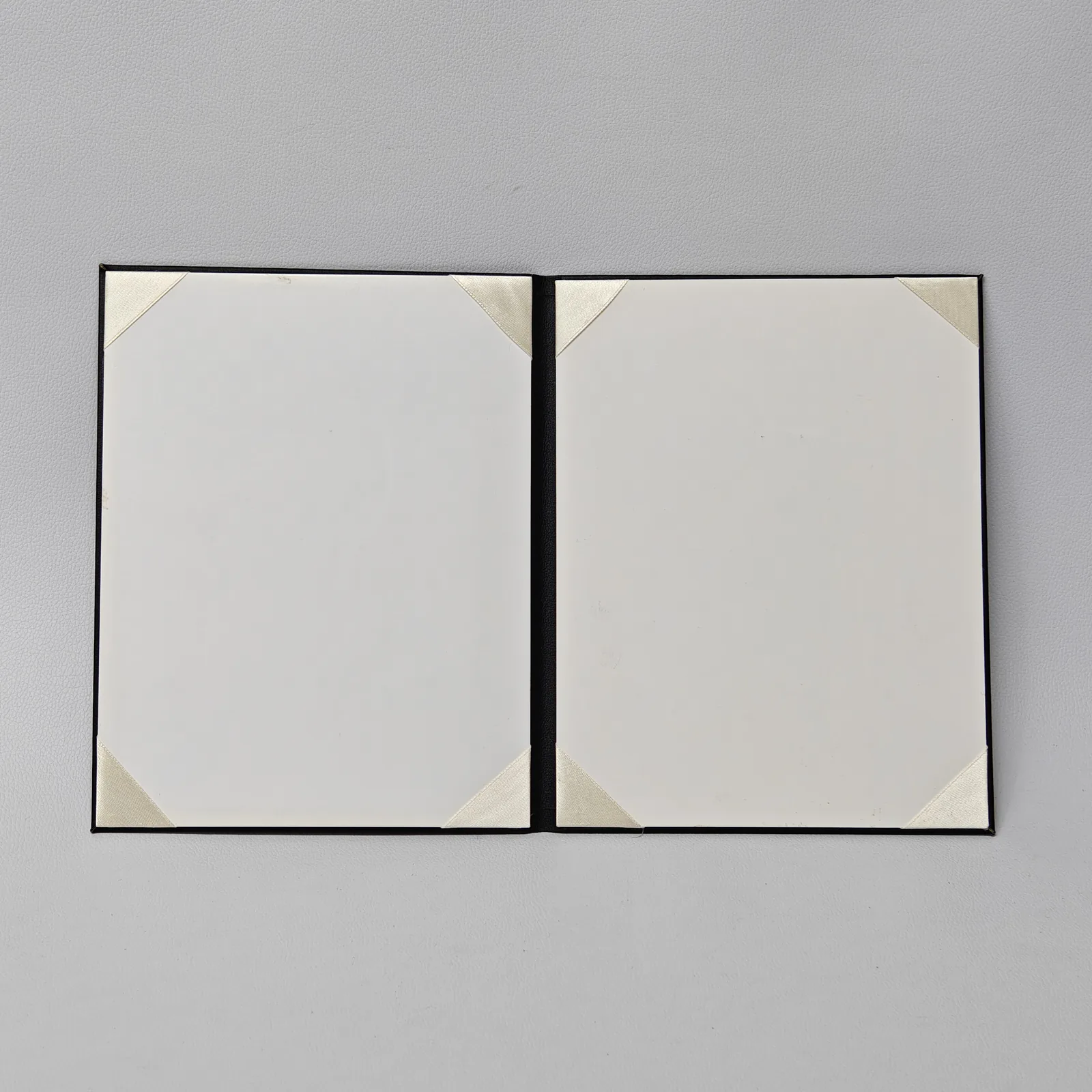 Open folder showing two white interior panels with cream ribbon corners for holding documents.