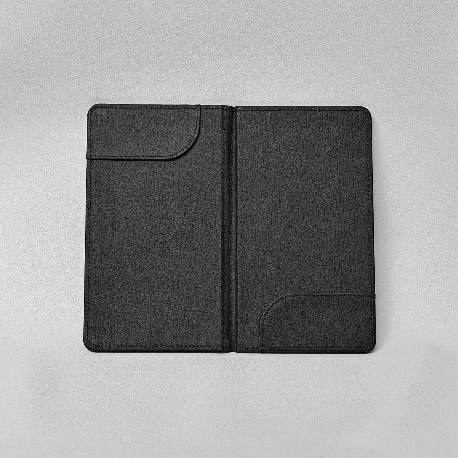 Interior of a black leather check presenter with two curved corner pockets.