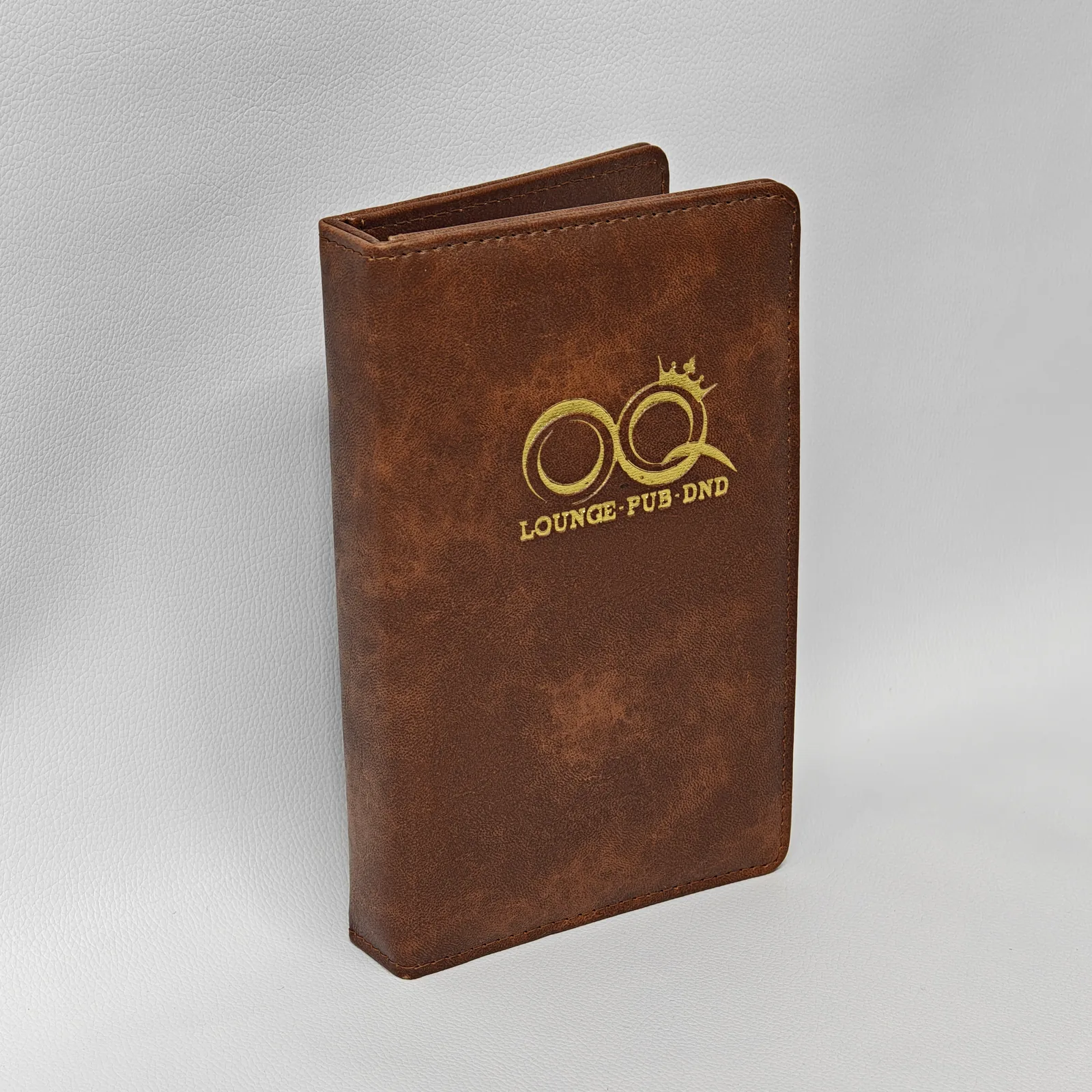 Side profile showing metal ring mechanism and leather spine