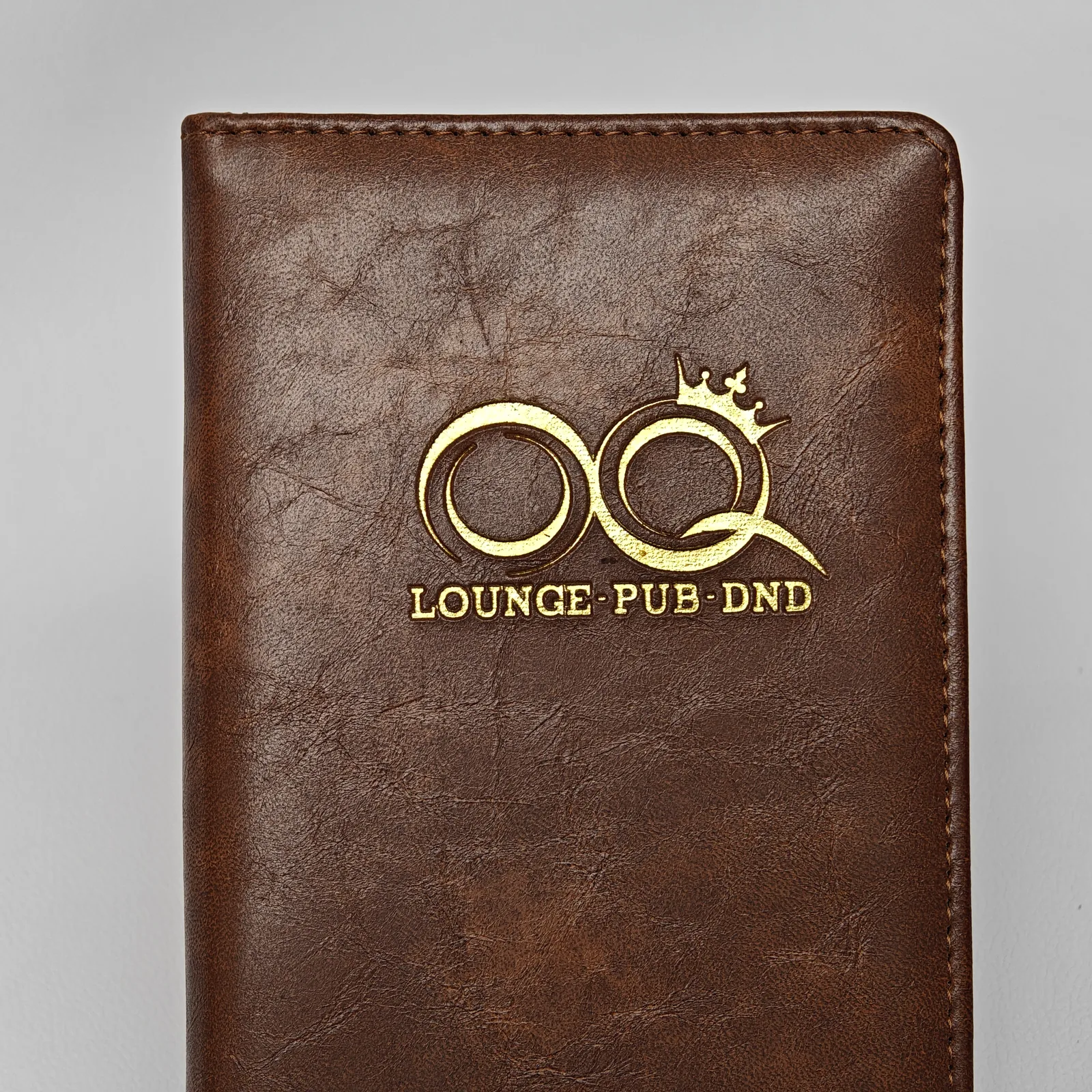 Brown leather bill presenter with embossed logo and rounded corners