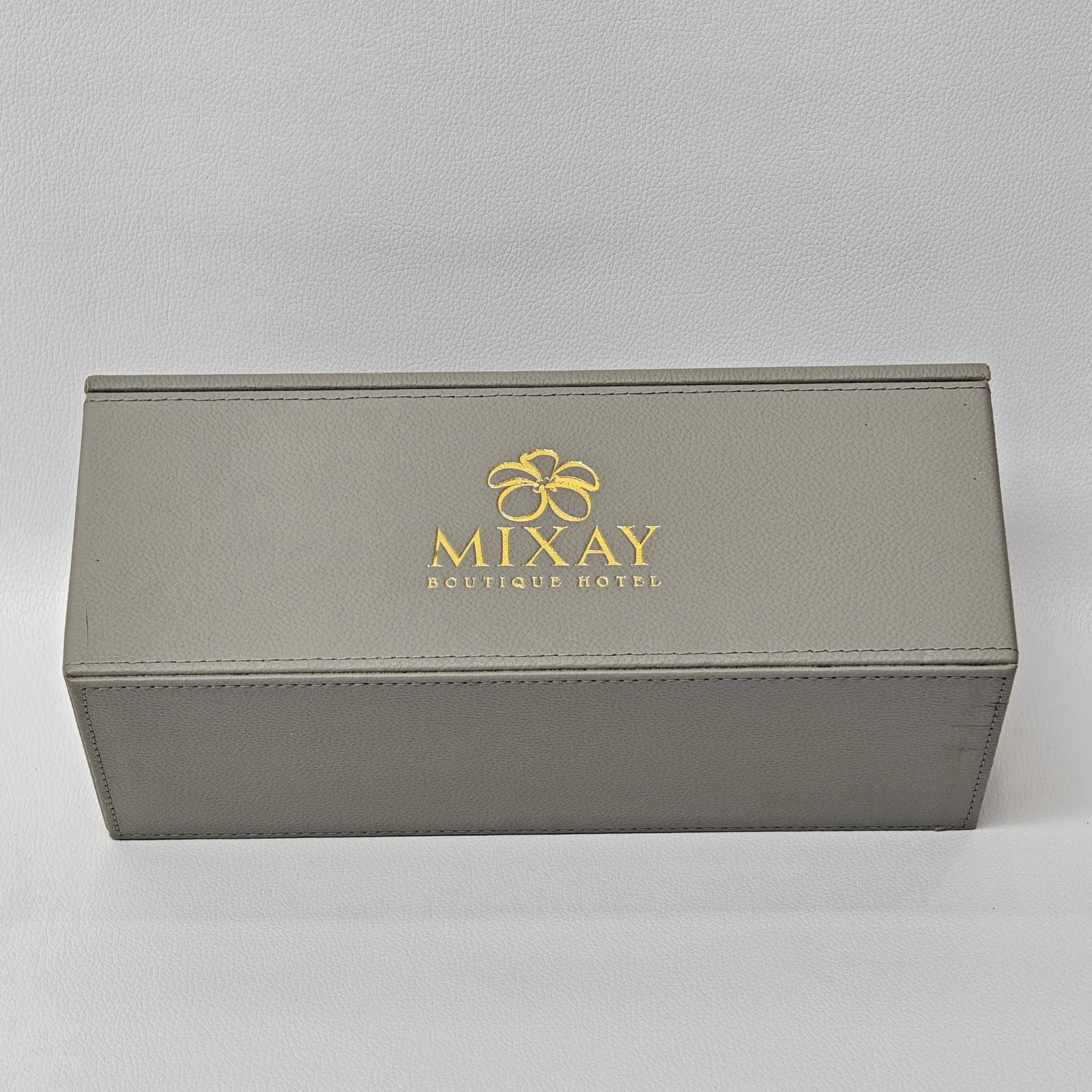 Closed amenity box with centered gold foil embossed logo