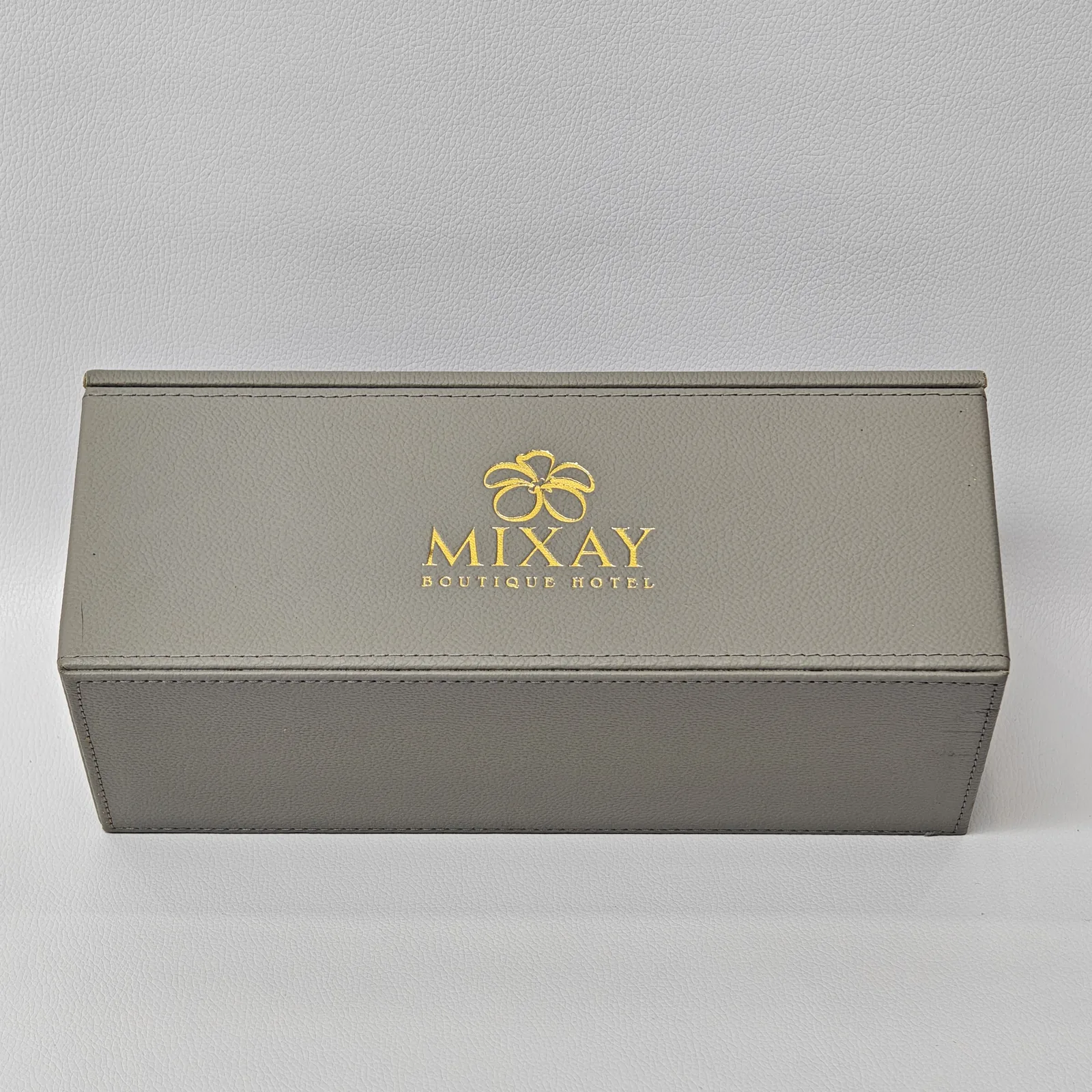 Sage leather hotel amenity box with embossed branding and hinged lid