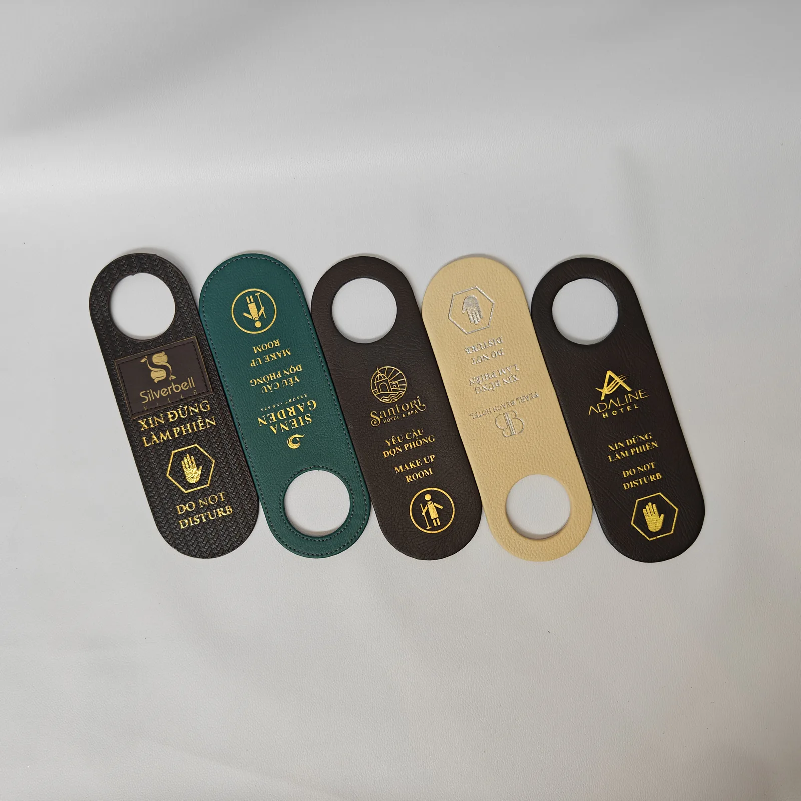 Overhead angle of leather door hanger collection showing stitching detail