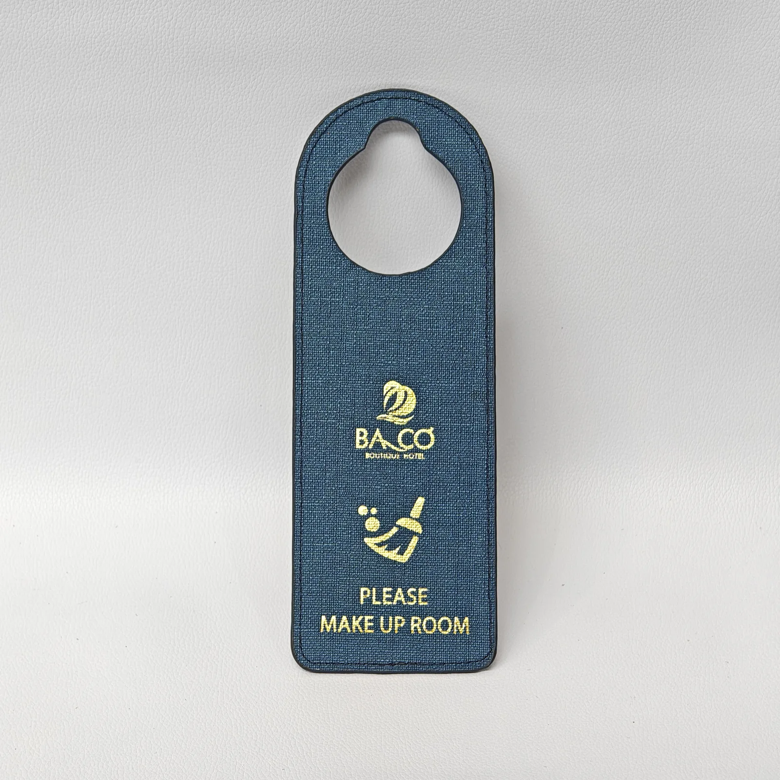 Close-up of canvas hotel door hanger showing woven texture and embossed text