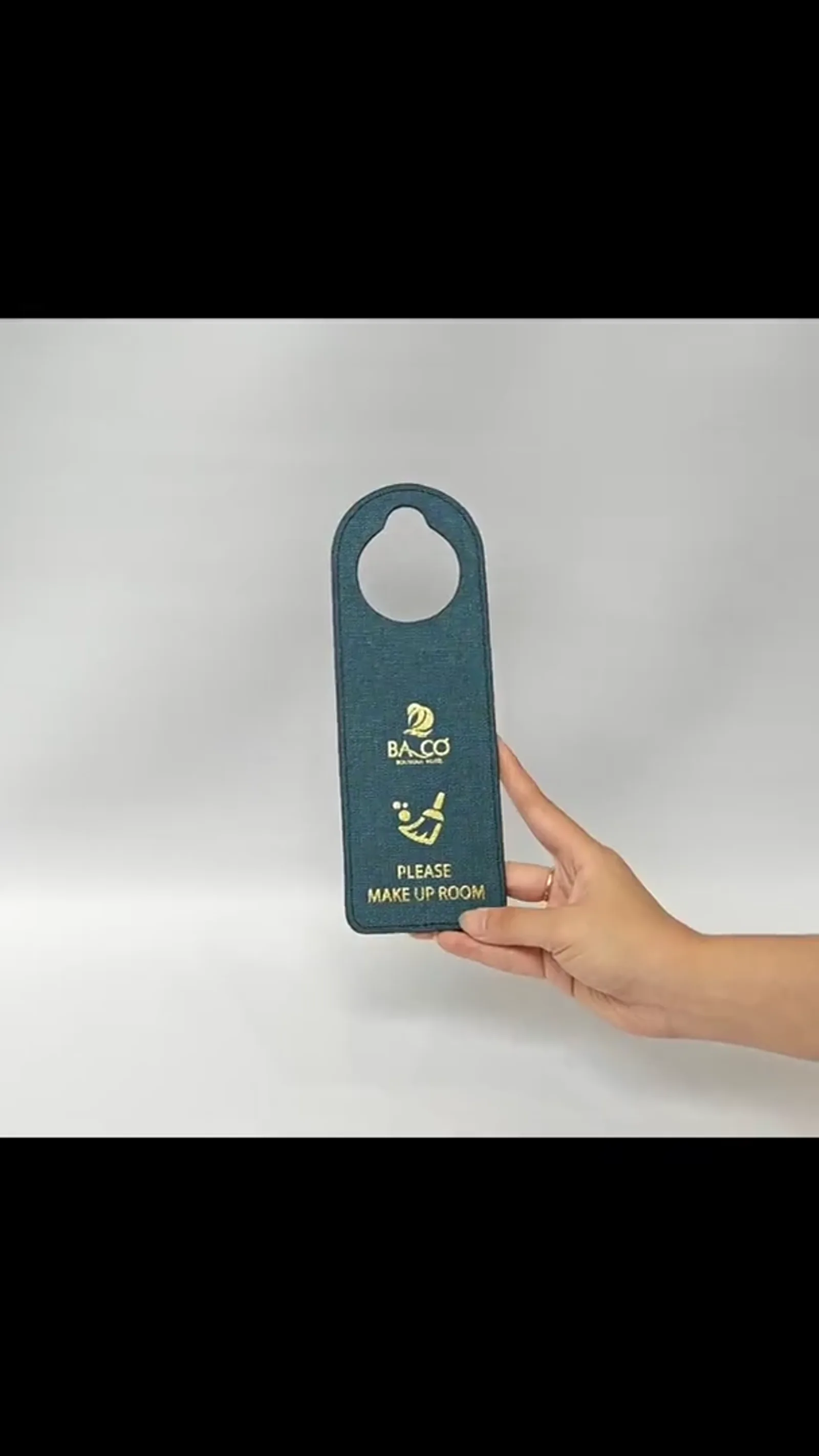 Canvas door hanger held in hand showing weave texture and gold embossing