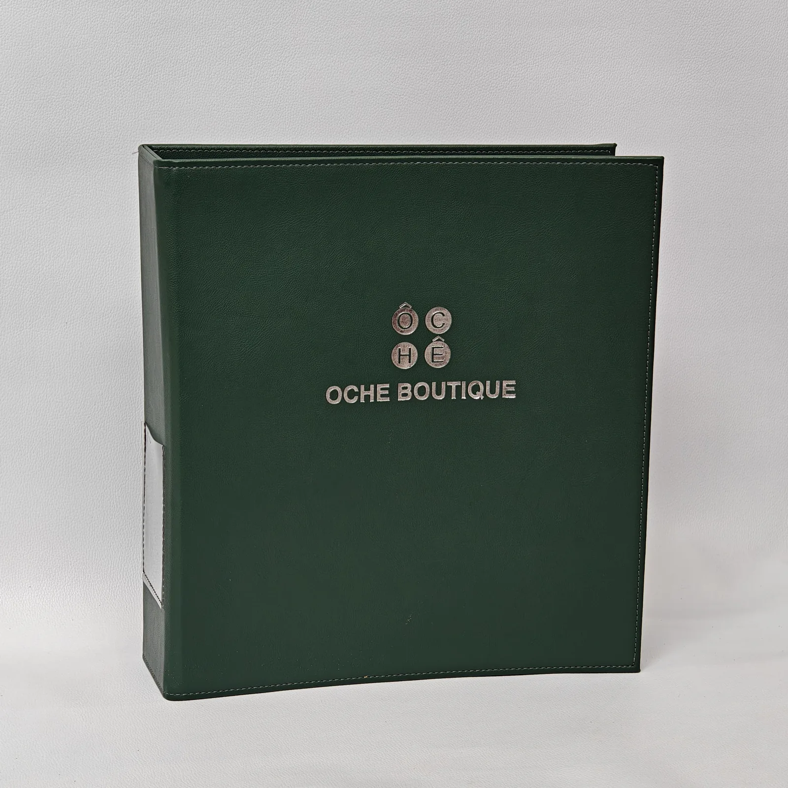 Dark green pebbled leather lever arch binder with a silver logo and spine label pocket.