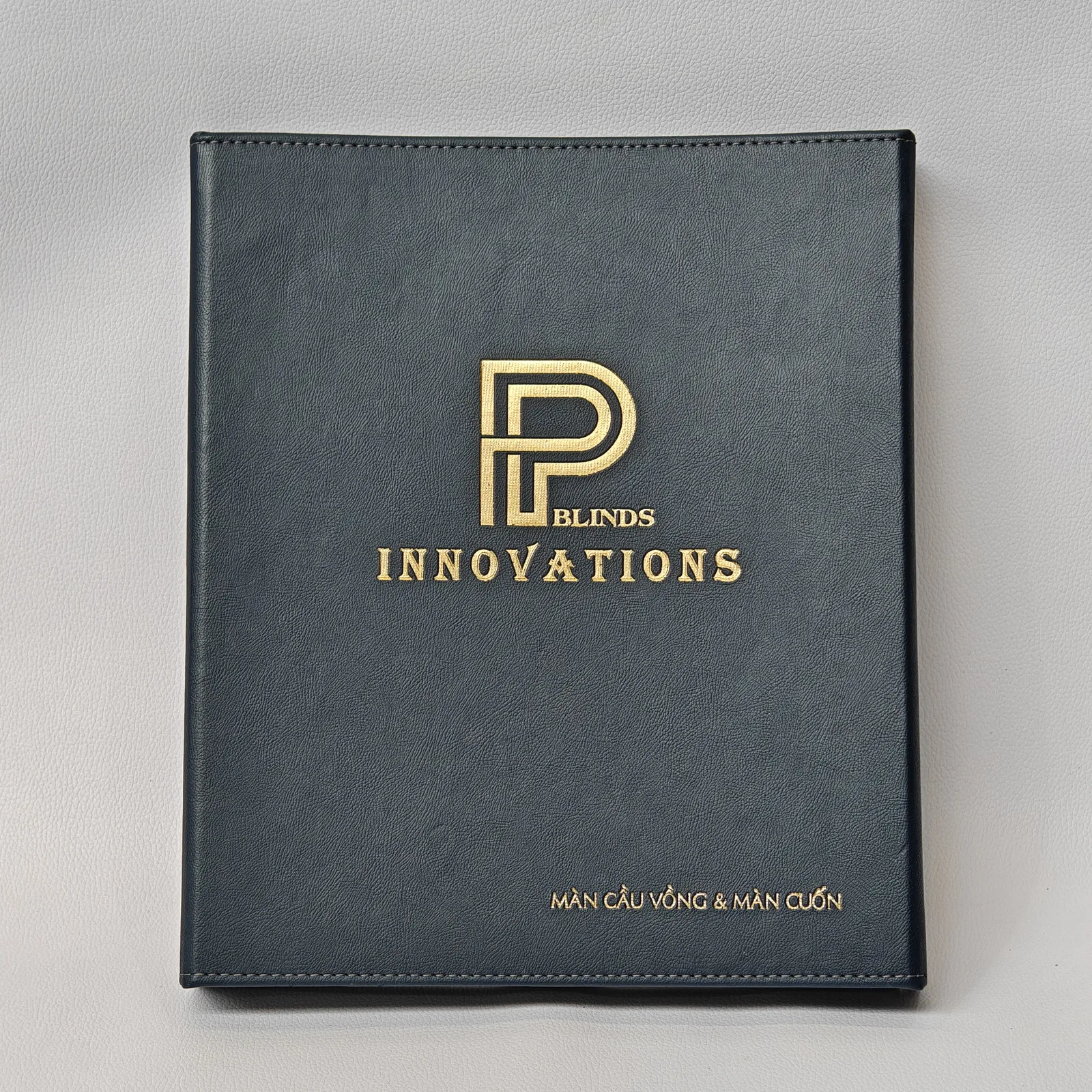Navy leather portfolio binder with gold foil branding and brass ring mechanism
