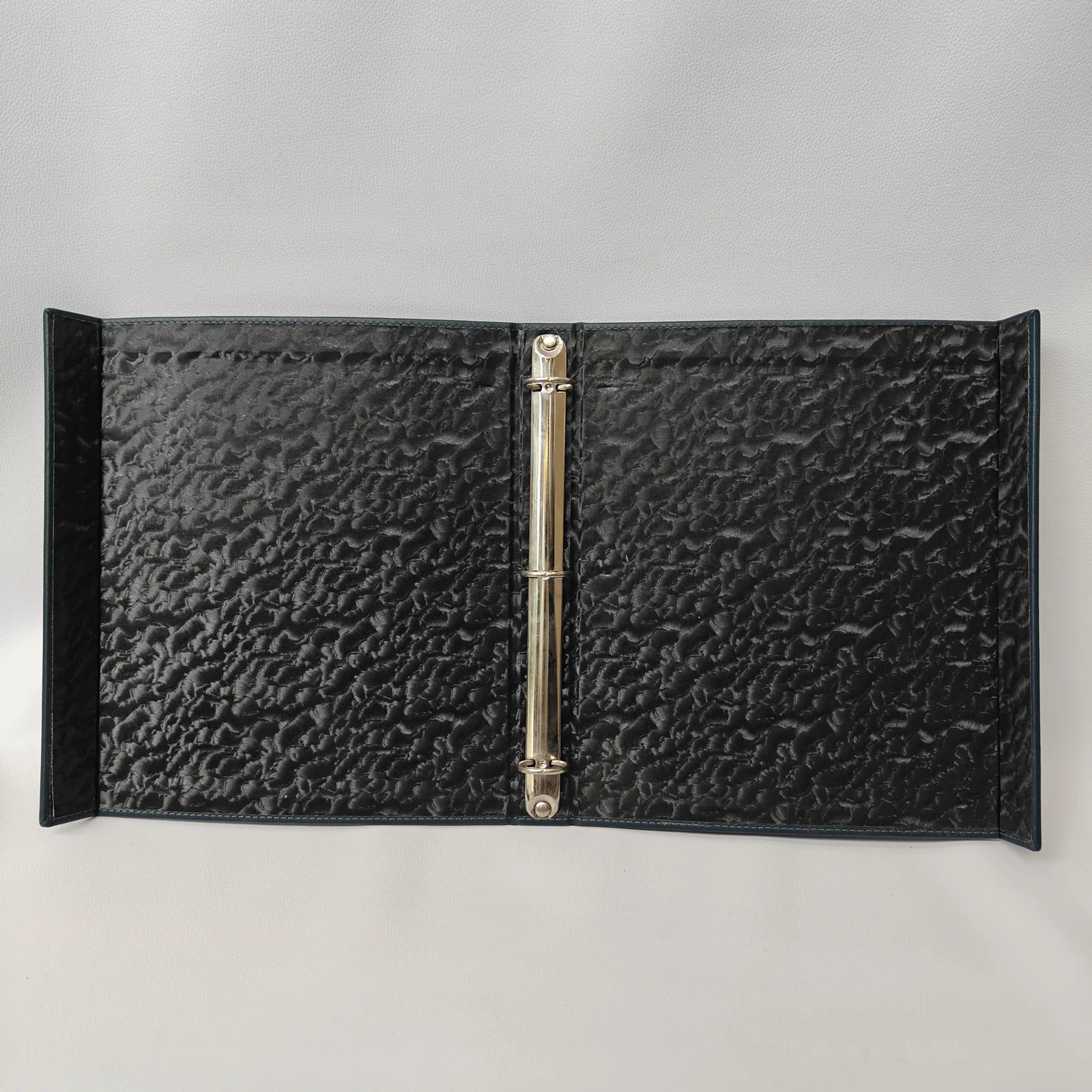 Open binder interior with pebbled leather and brass ring document fastener