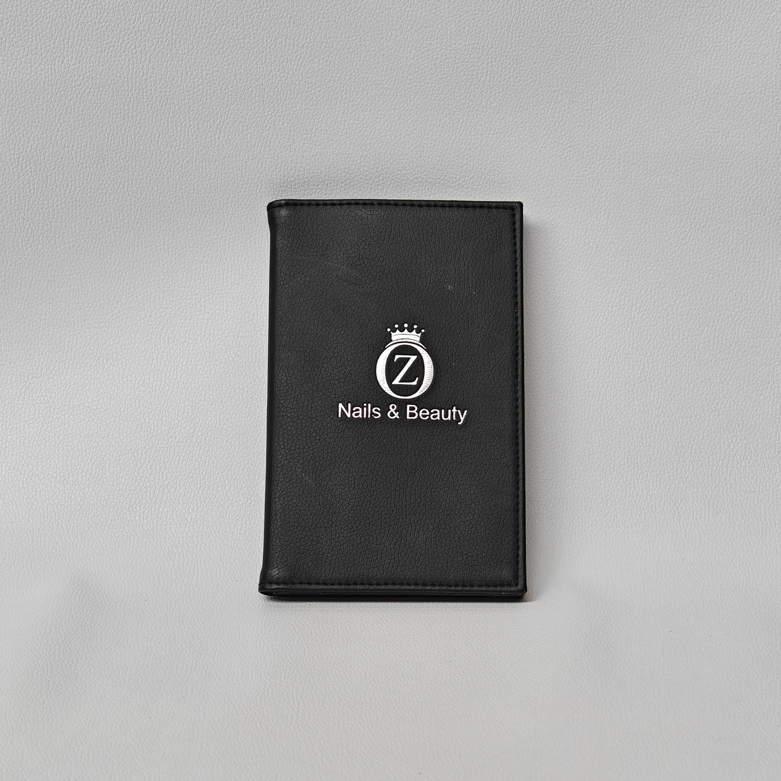 Black compact leather bill presenter with snap closure and embossed logo