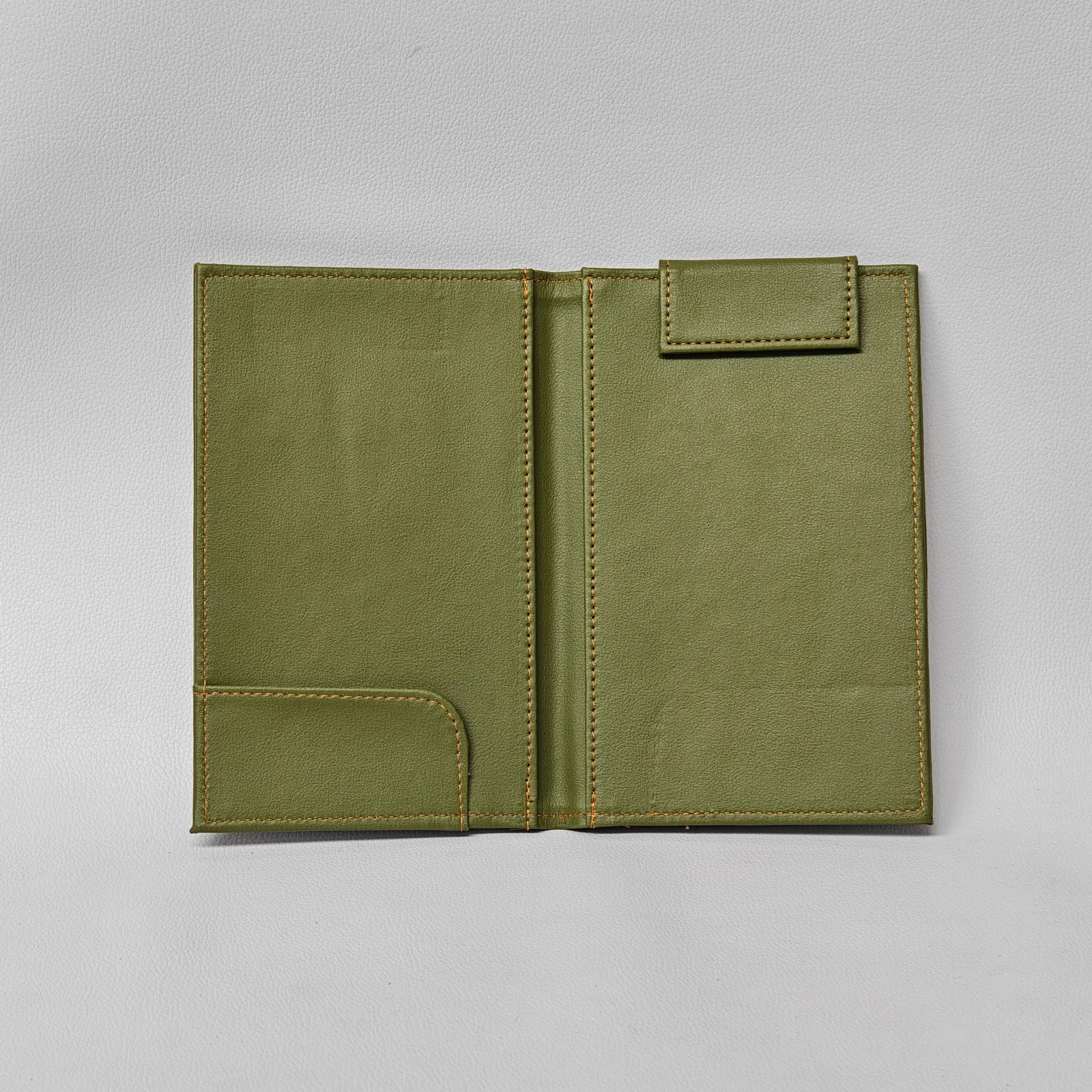 Open interior of an olive green leather check presenter with a corner pocket and a top magnetic tab.