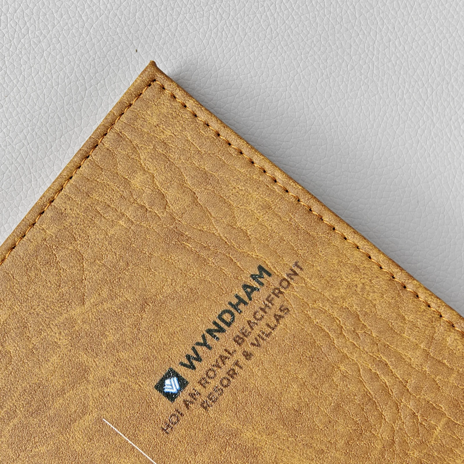 Embossed logo detail on aged leather corner
