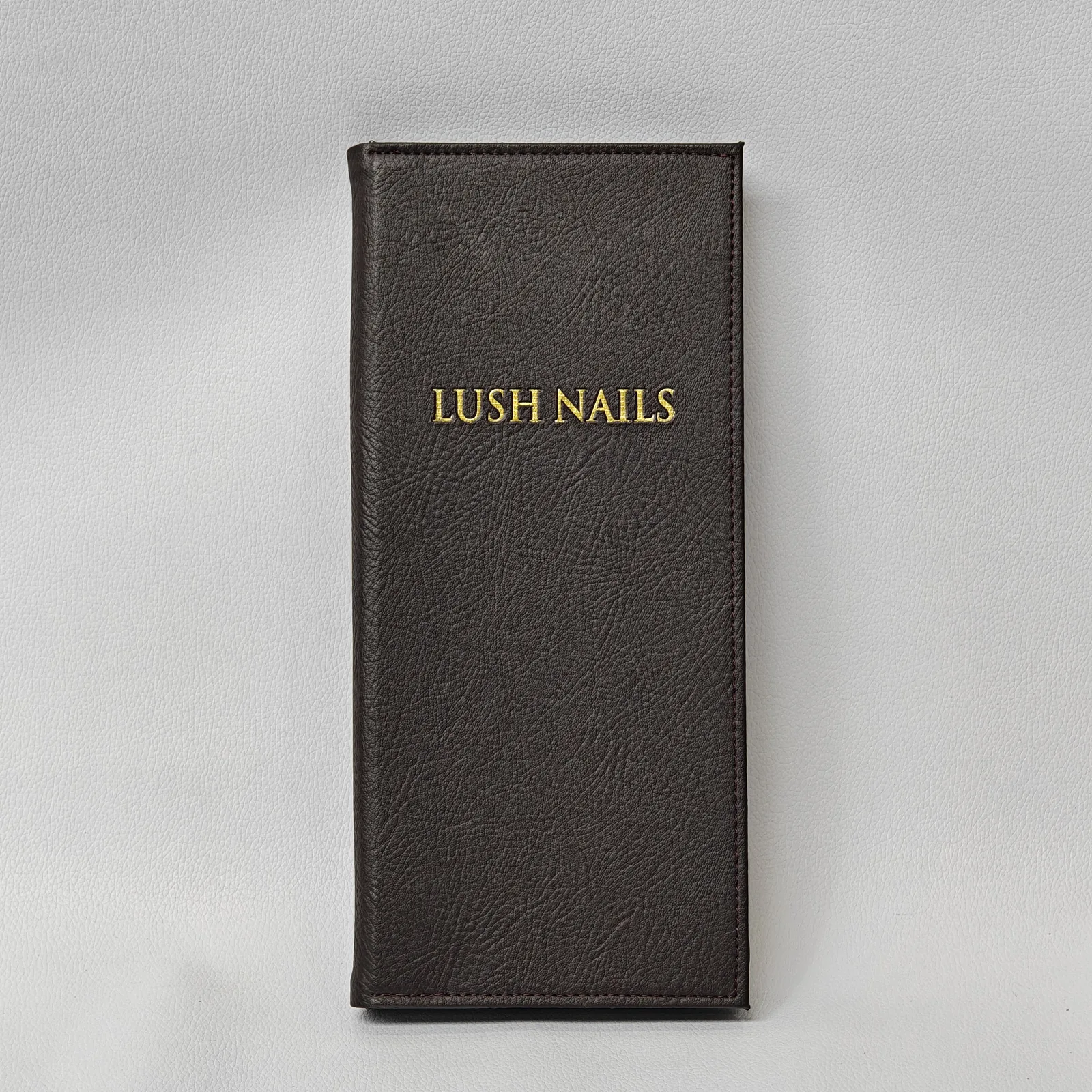 Dark leather service brochure with gold embossed text and logo