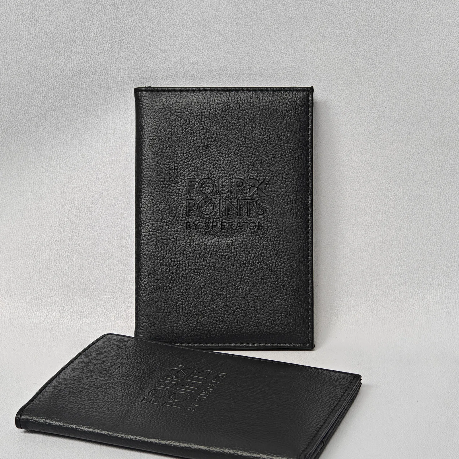 Black leather bill presenter with blind emboss branding, 13 × 21.5 cm compact size