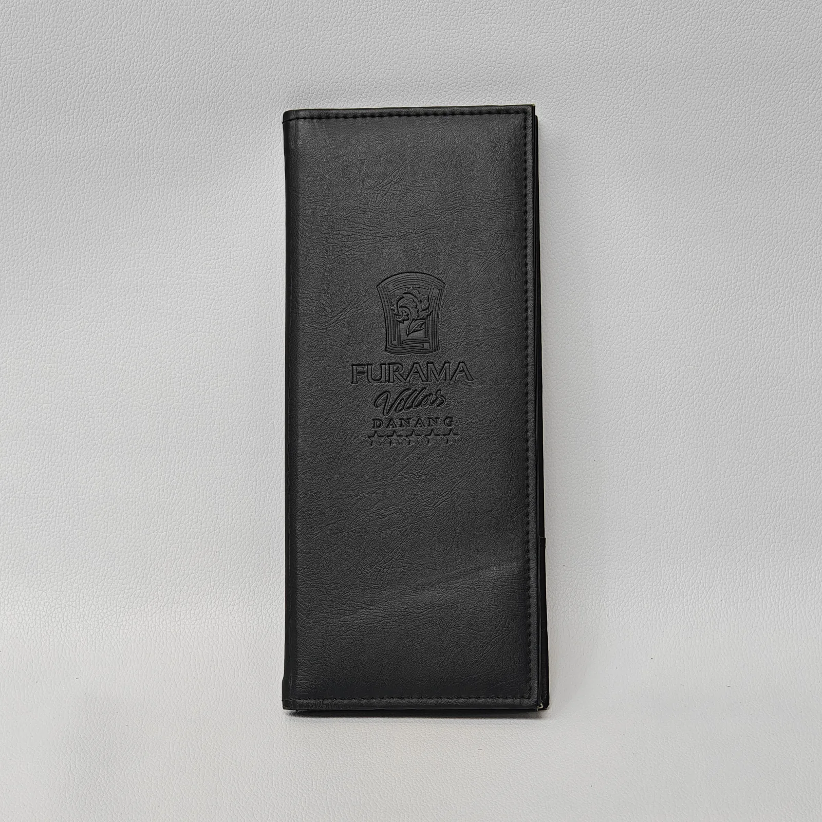 Black leather menu holder at side angle showing construction and depth