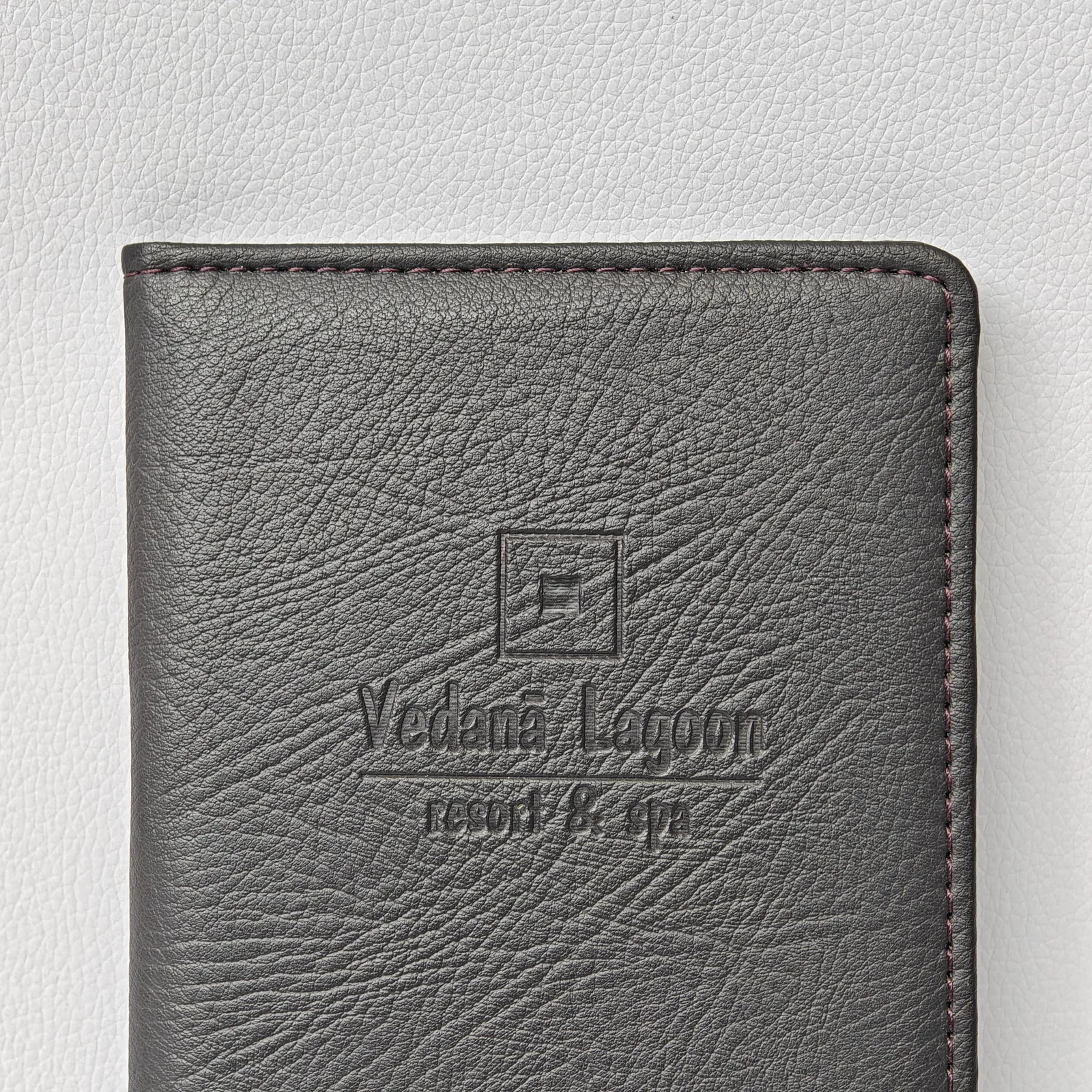 Charcoal gray leather check presenter at angle showing texture and finish