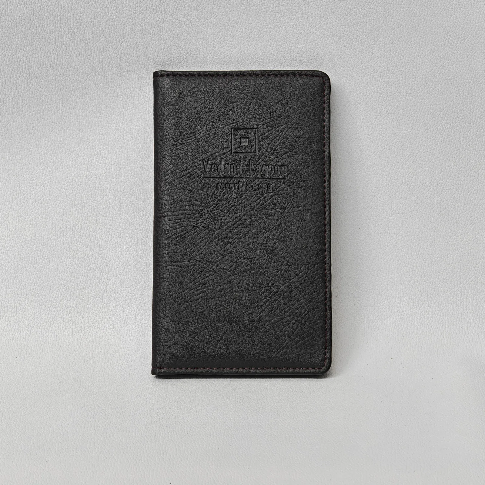 Black leather check presenter with embossed branding, front view