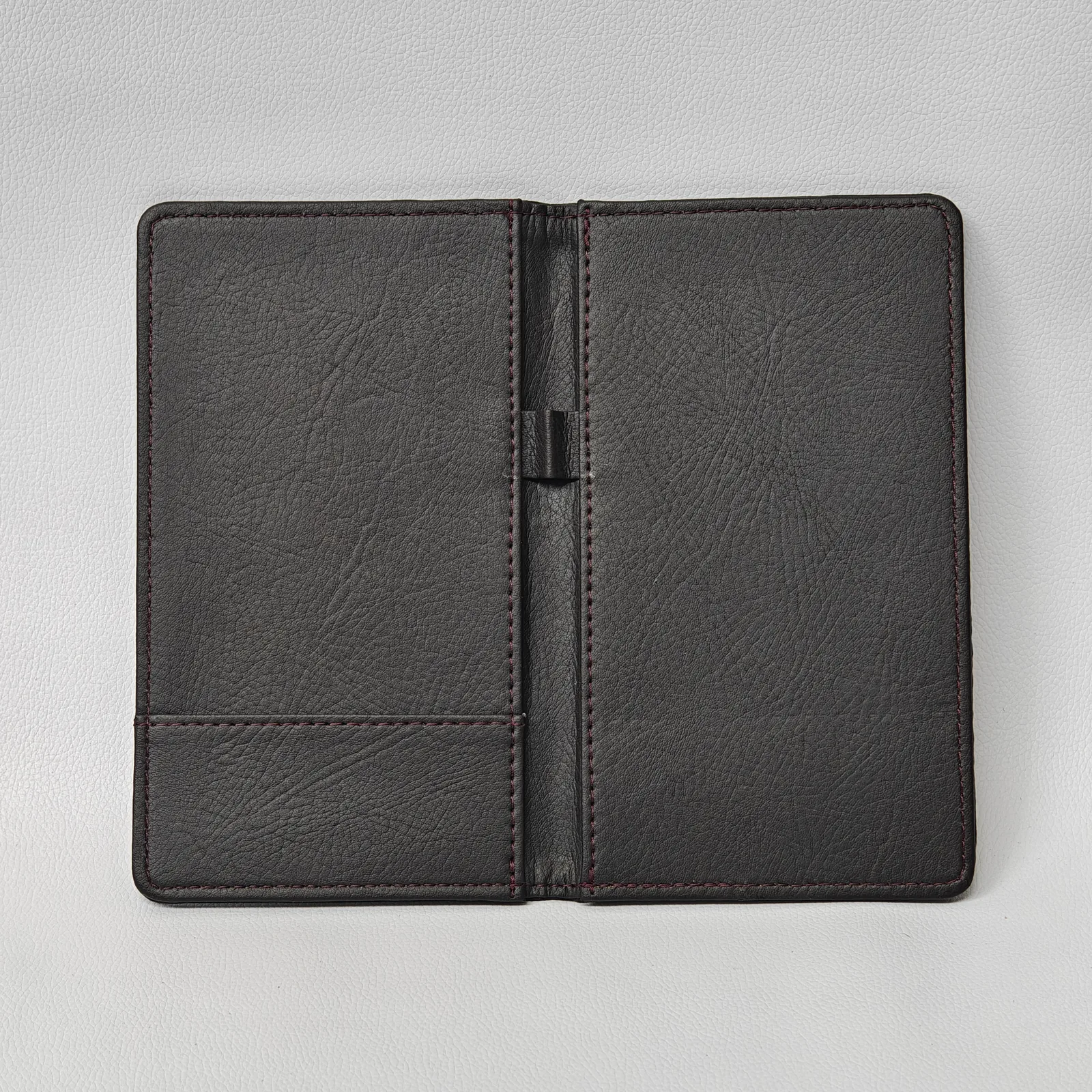 Tan leather spiral-bound check presenter with metal binding rings in use