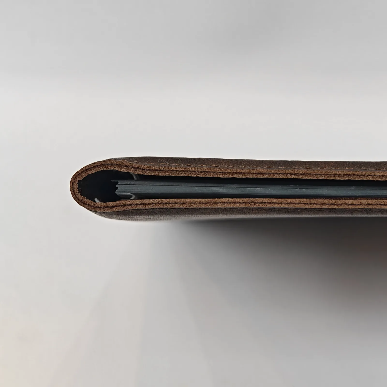 Side view of the menu cover spine showing the thickness and internal spiral binding.
