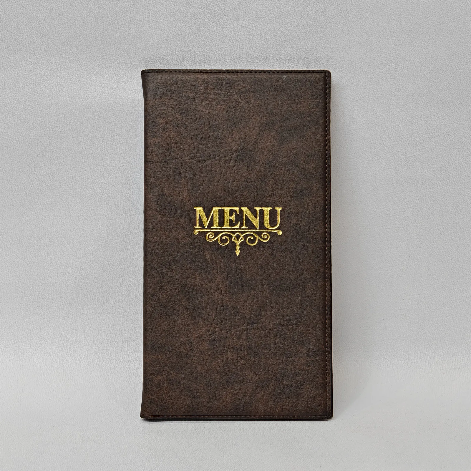 Front view of a brown leather menu cover with a gold foil stamped MENU logo.