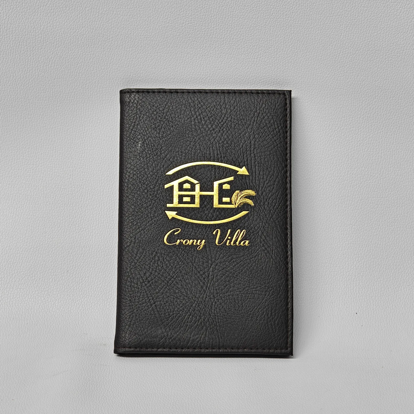 Black leather bill presenter with centered gold foil embossed logo