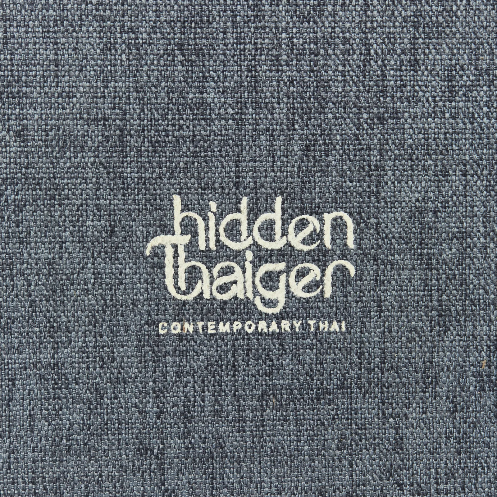 Close-up of woven canvas texture with embossed branding