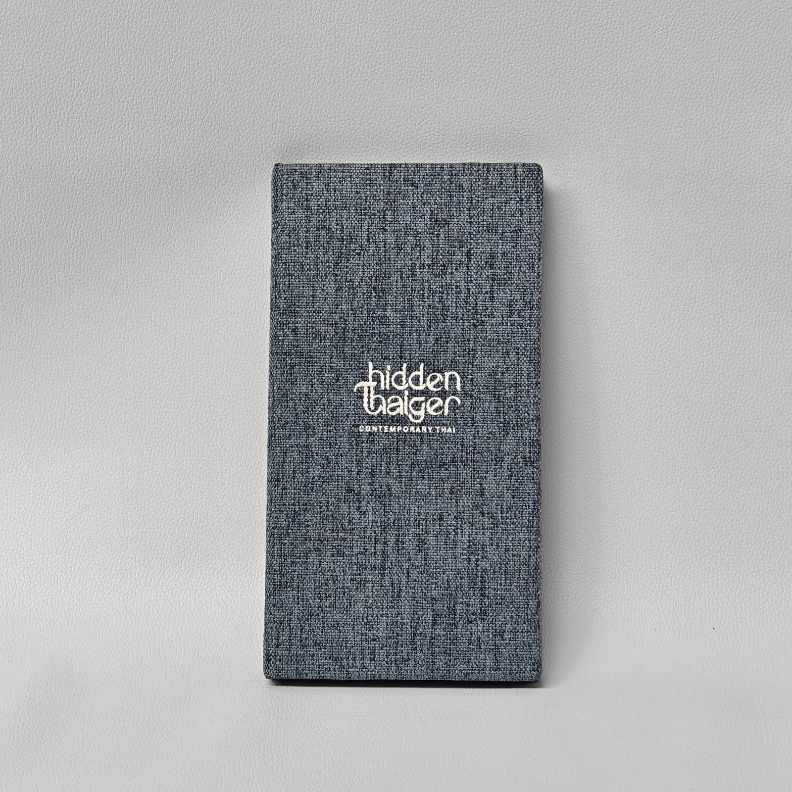 Two-tone canvas and leather menu cover with embossed branding